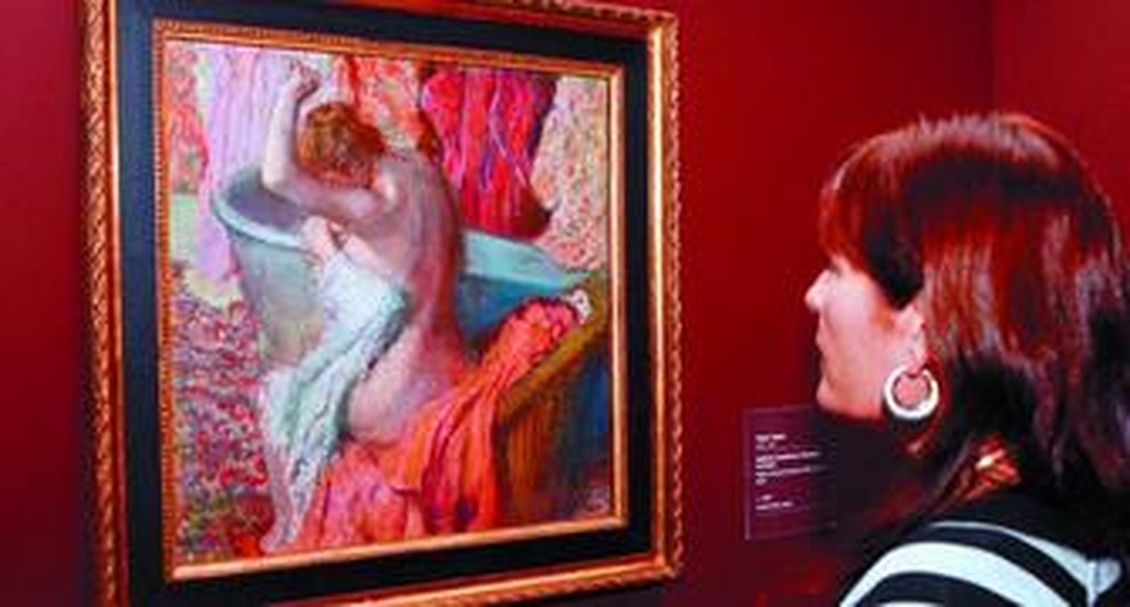 Una mujer contempla 'Bañista secándose', de Edgar Degas, una de las 71 obras presentes en la exposición.