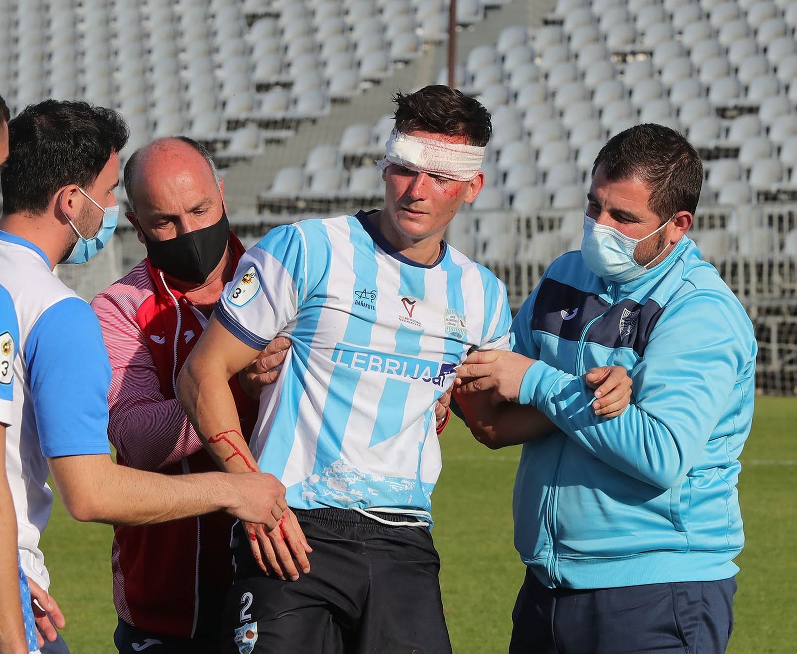 Juanma, lateral de la Lebrijana, es atendido en un partido.