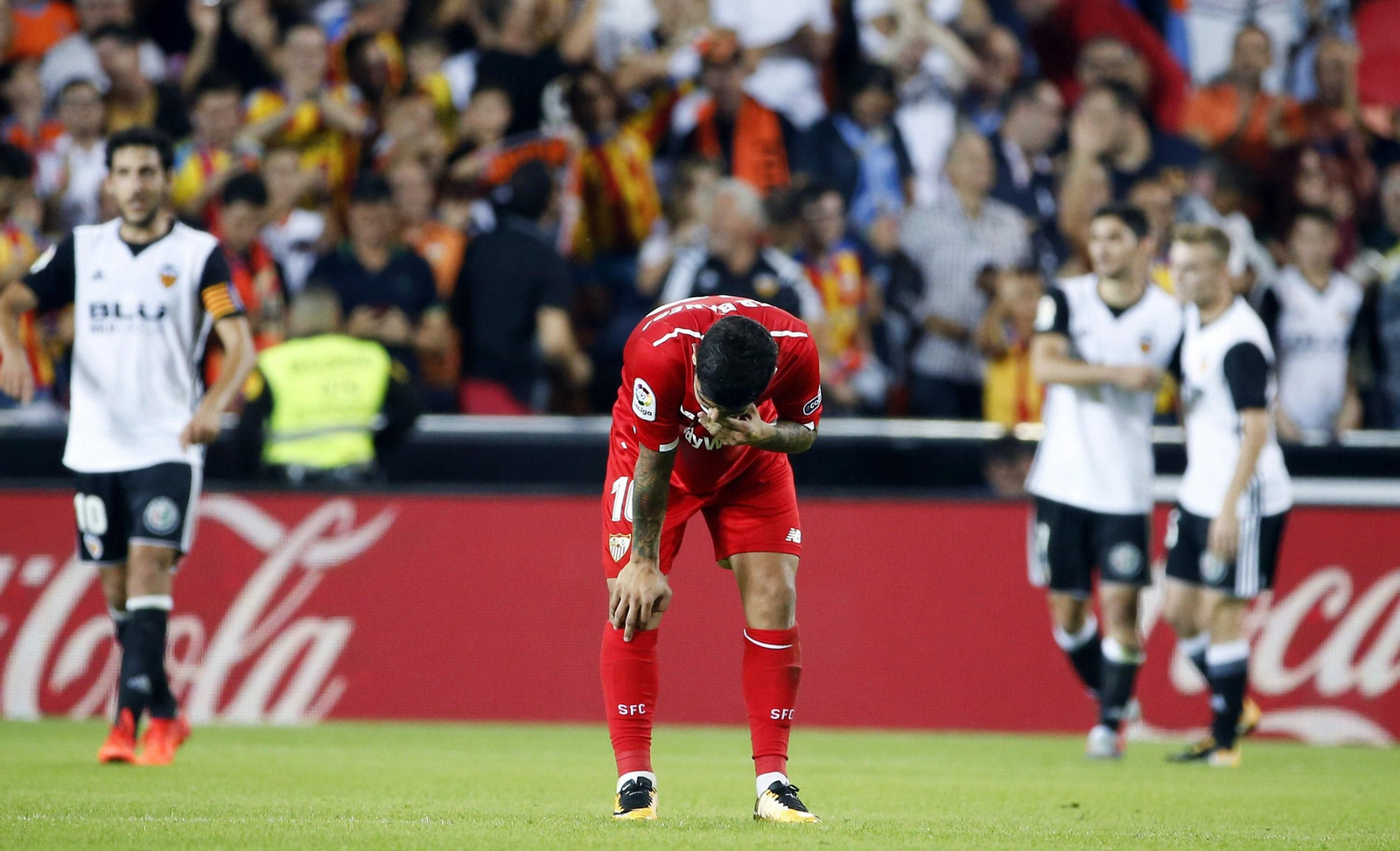 Banega se lamenta mientras Guedes celebra al fondo uno de sus dos goles al Sevilla.