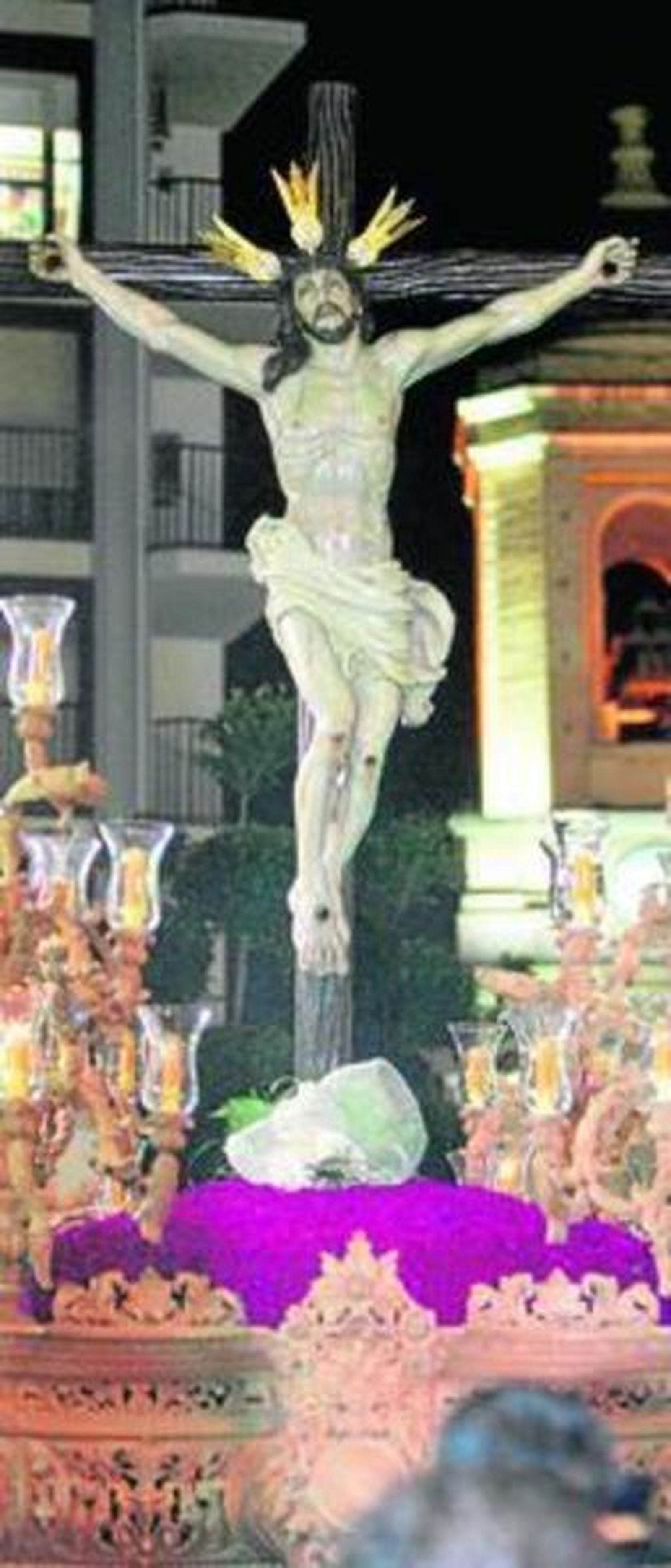 El Santísimo Cristo del Amor con el campanario de San Sebastián al fondo.