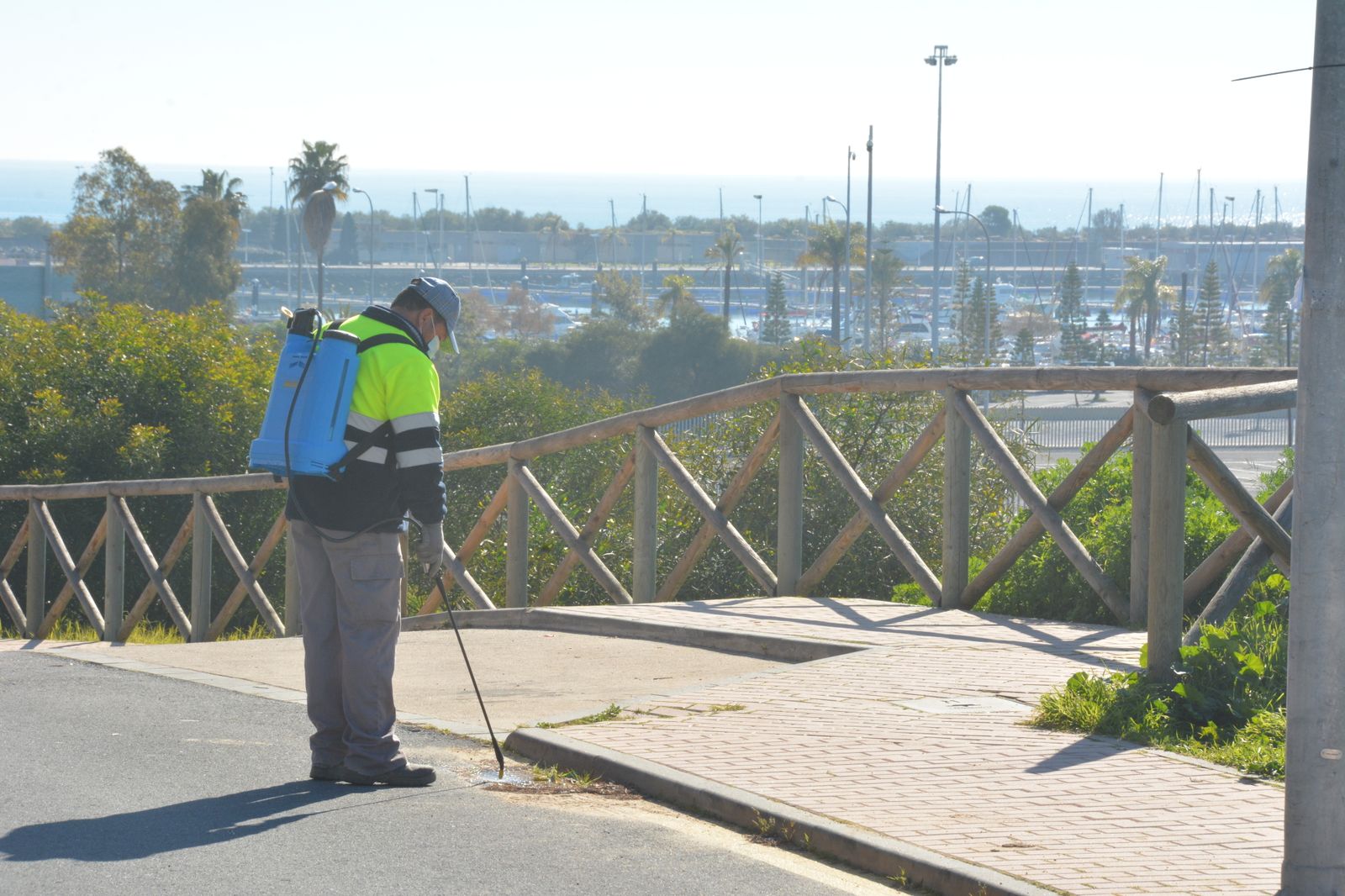 Un operario fumiga una de las rejillas del alcantarillado en el municipio palermo.