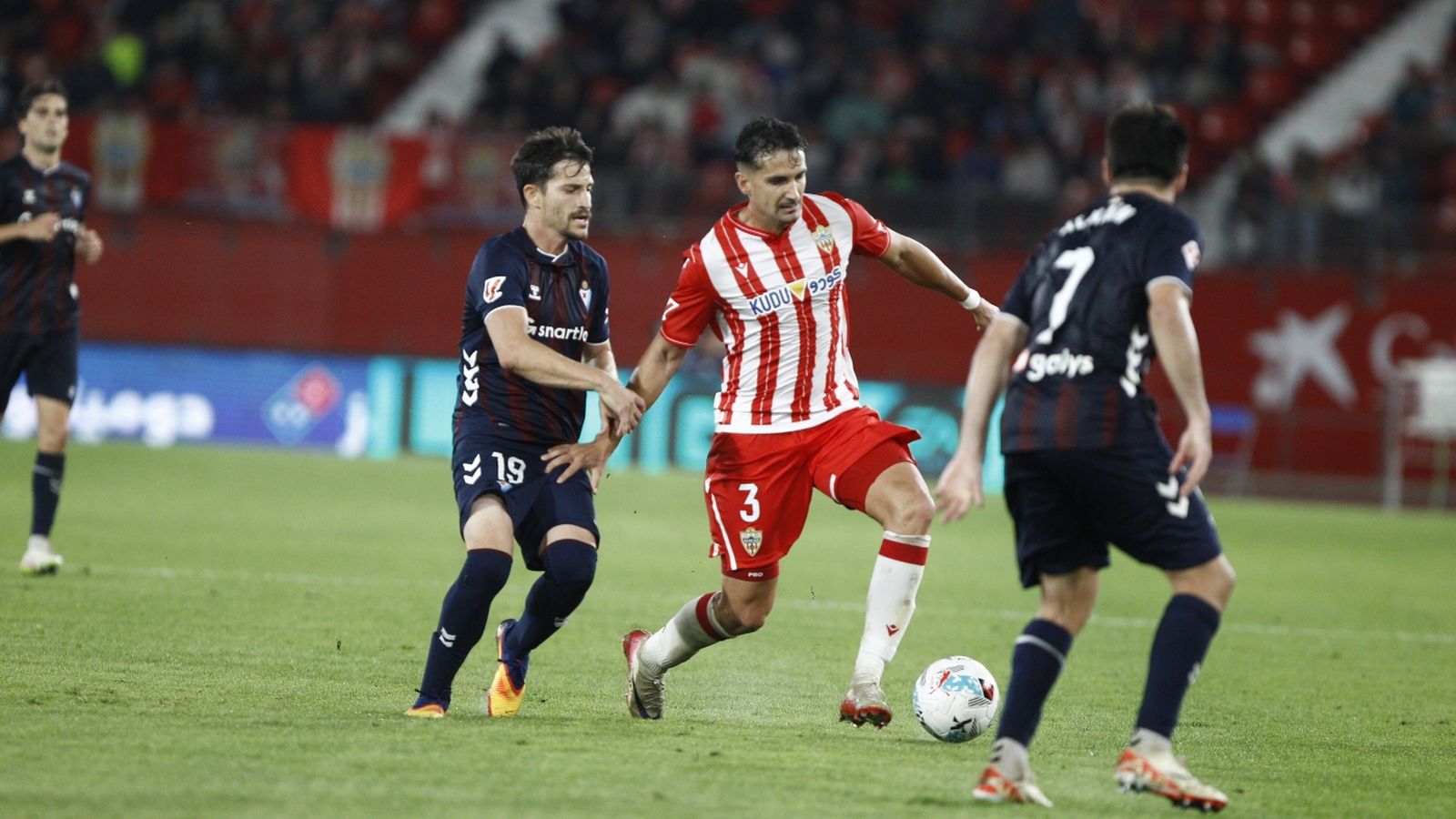 Álex Muñoz trata de avanzar con el esférico ante la presión de Toni Villa.