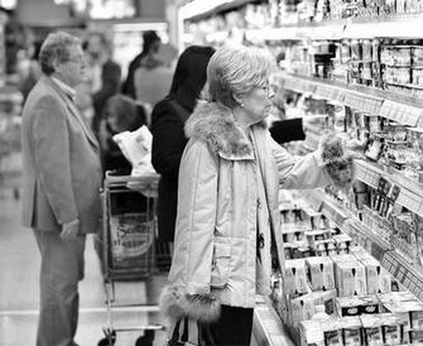 Varias personas adquieren productos en un supermercado.