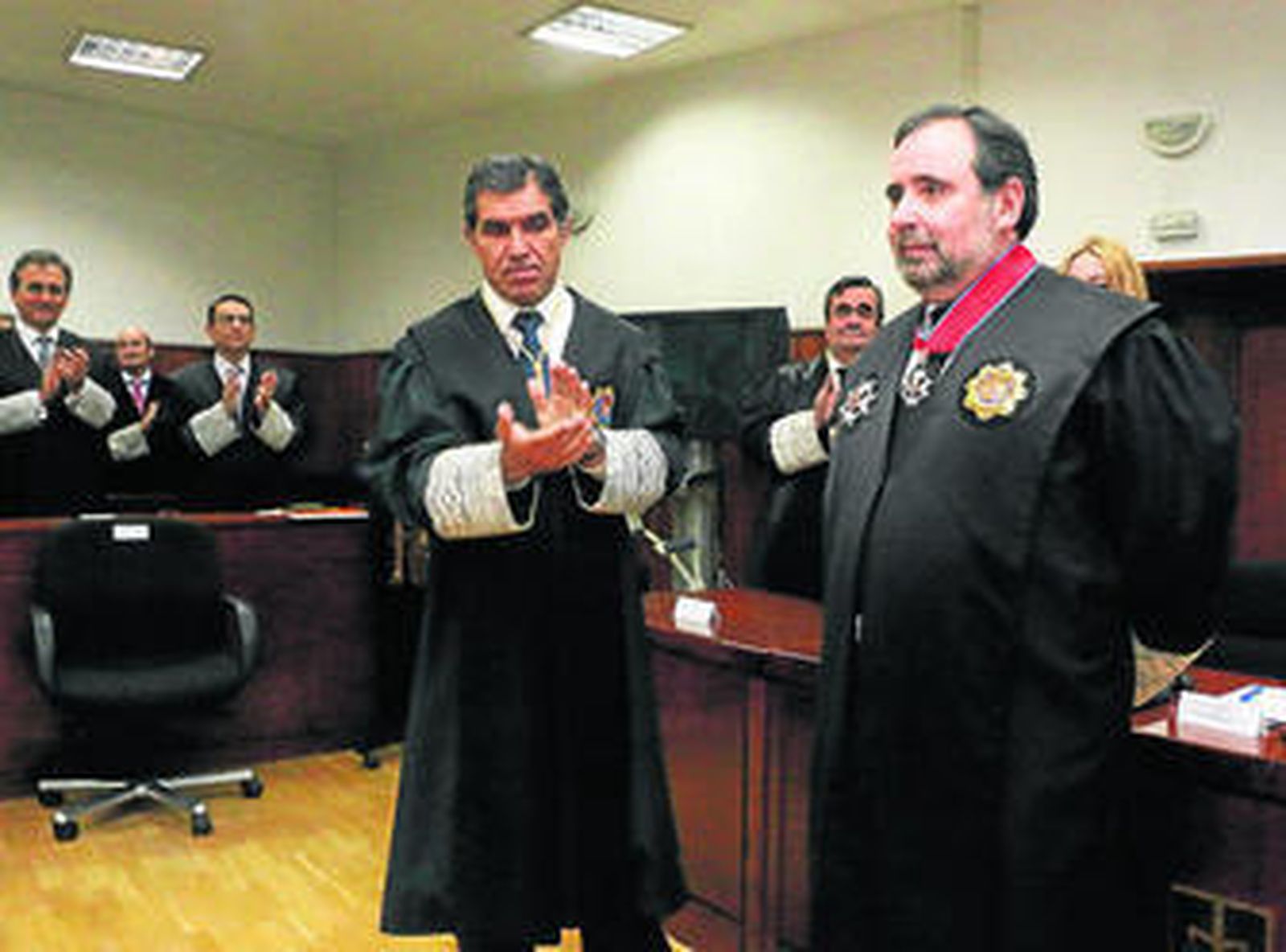 El presidente del TSJA aplaude a José María Magaña tras recibir la distinción.