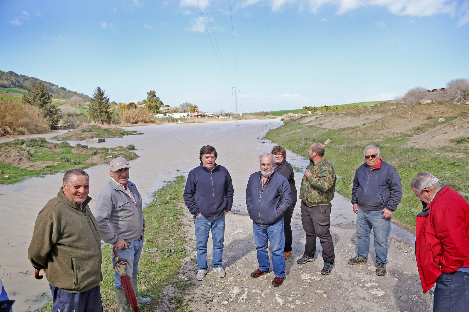 Vecinos de la Cañada del Carrillo en el lugar donde el carril que les conduce a sus casas desaparece bajo el agua.