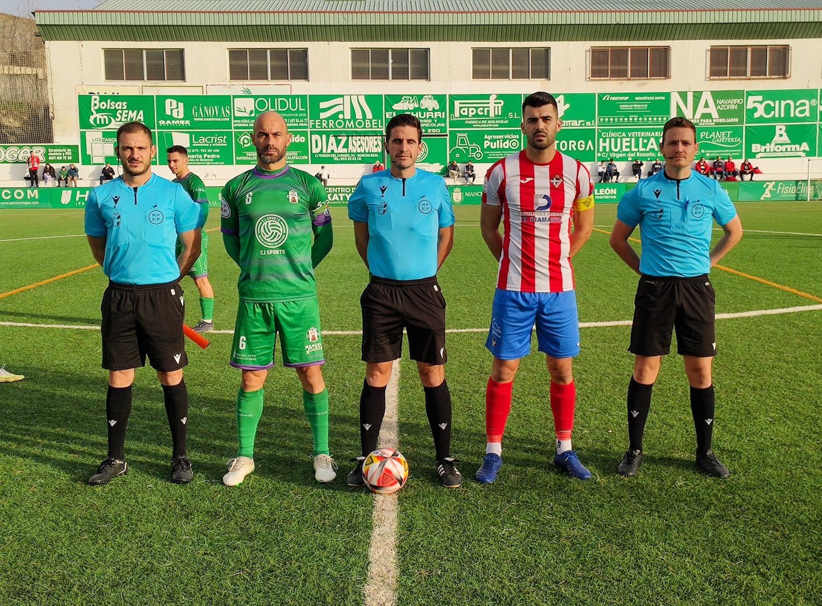 Los capitanes de ambos equipos posan con el trío arbitral antes del partido en Mancha Real.
