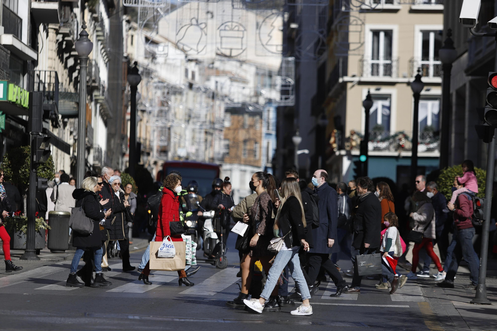 Peatones cruzan la céntrica calle Reyes Católicos de Granada, donde ya podrían abrir los comercios sin limitación horaria