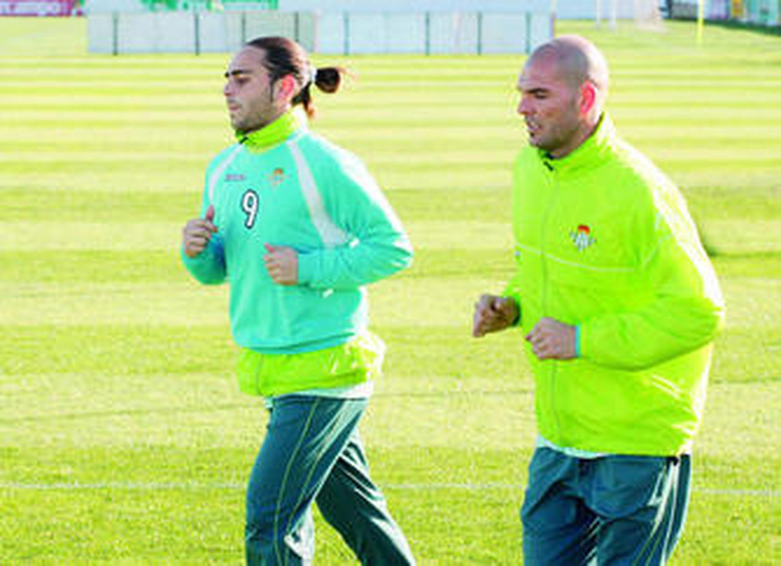 Juanito conduce el balón entre Óscar López y Juande.