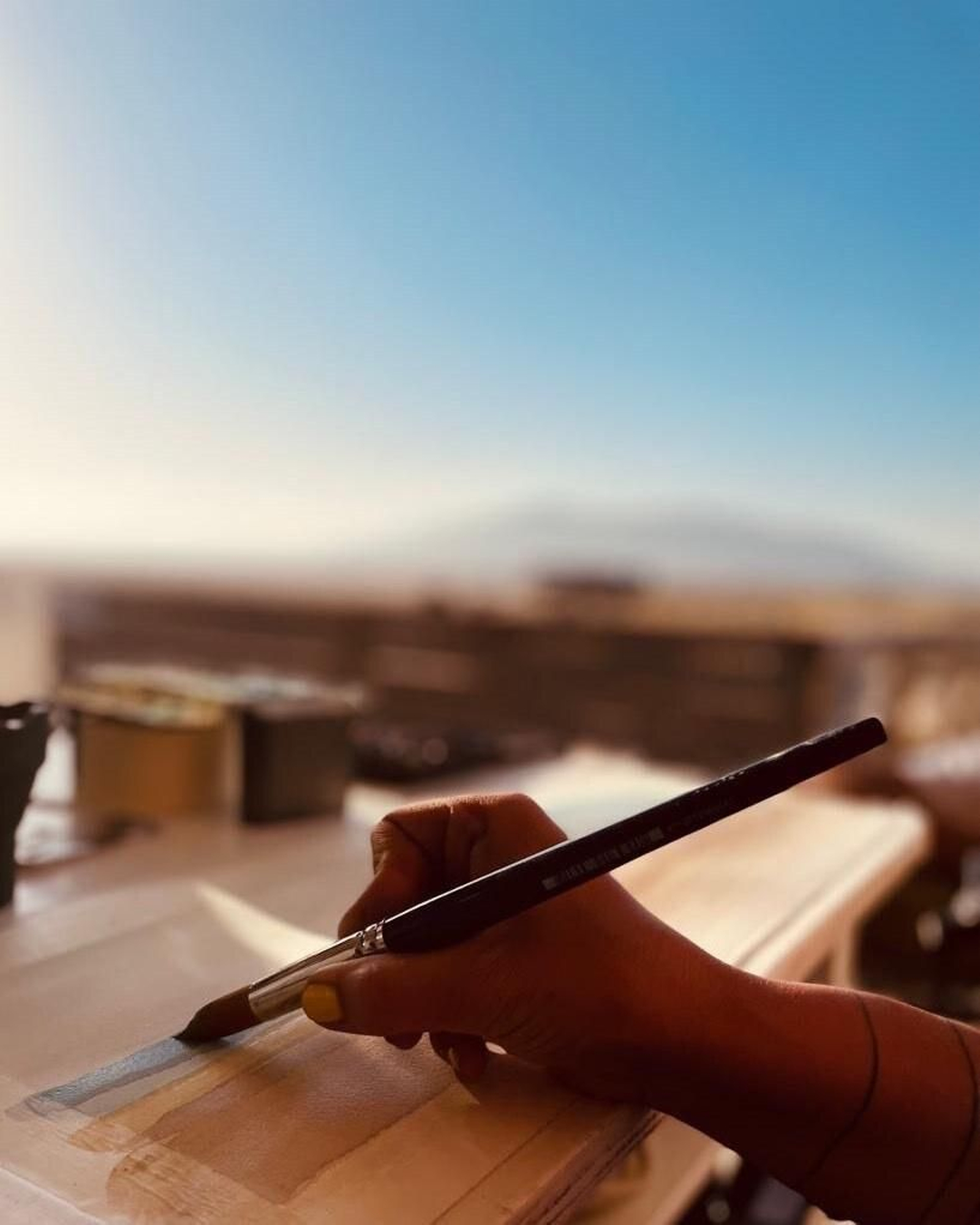 Neila Pascual con sus acuarelas en el chiringuito tarifeño de 'Carbones 13'