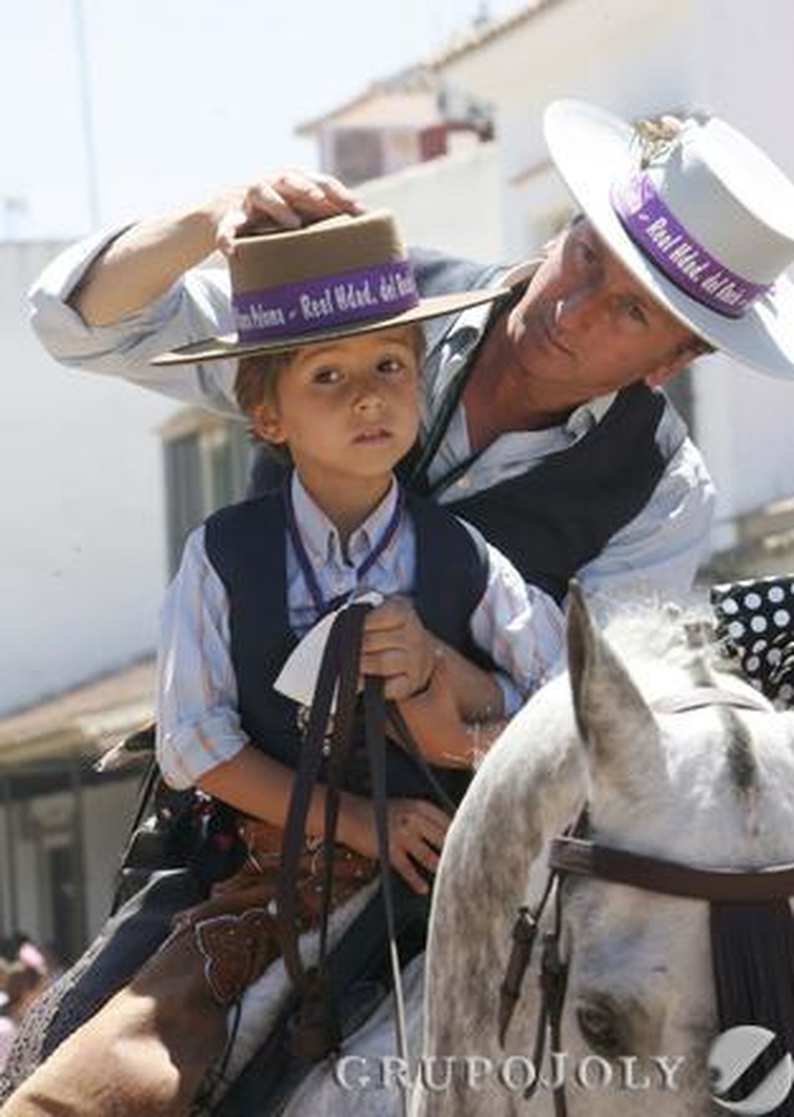 La devoción por la Virgen se transmite de generación en generación. En esta imagen, una familiar estampa en la que un padre coloca el sombrero al hijo mientras van a caballo

Foto: Pascual
