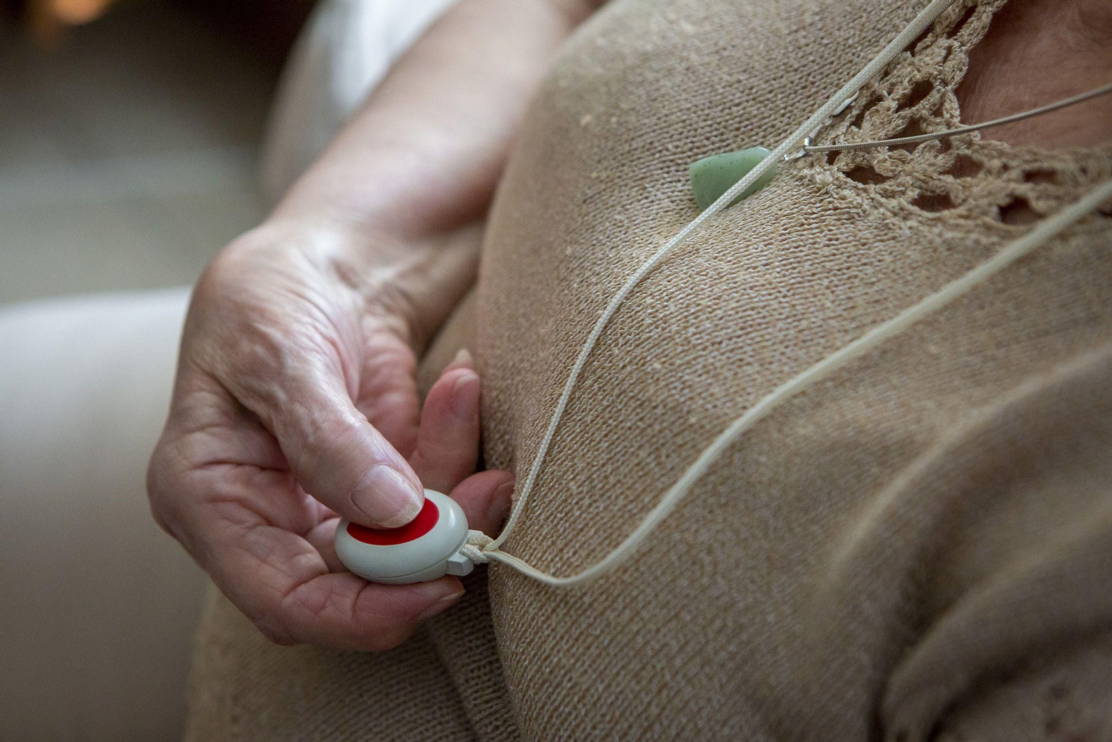 Una mujer ataviada con el dispositivo de la teleasistencia por dependencia.