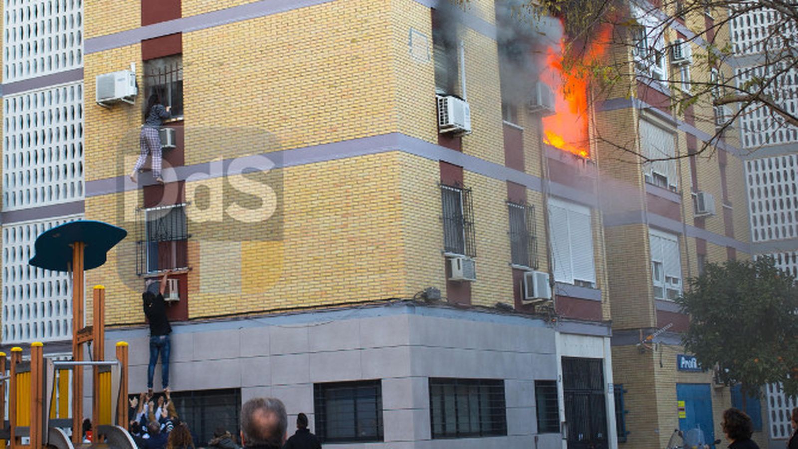 Dos personas escapan de las llamas por una ventana