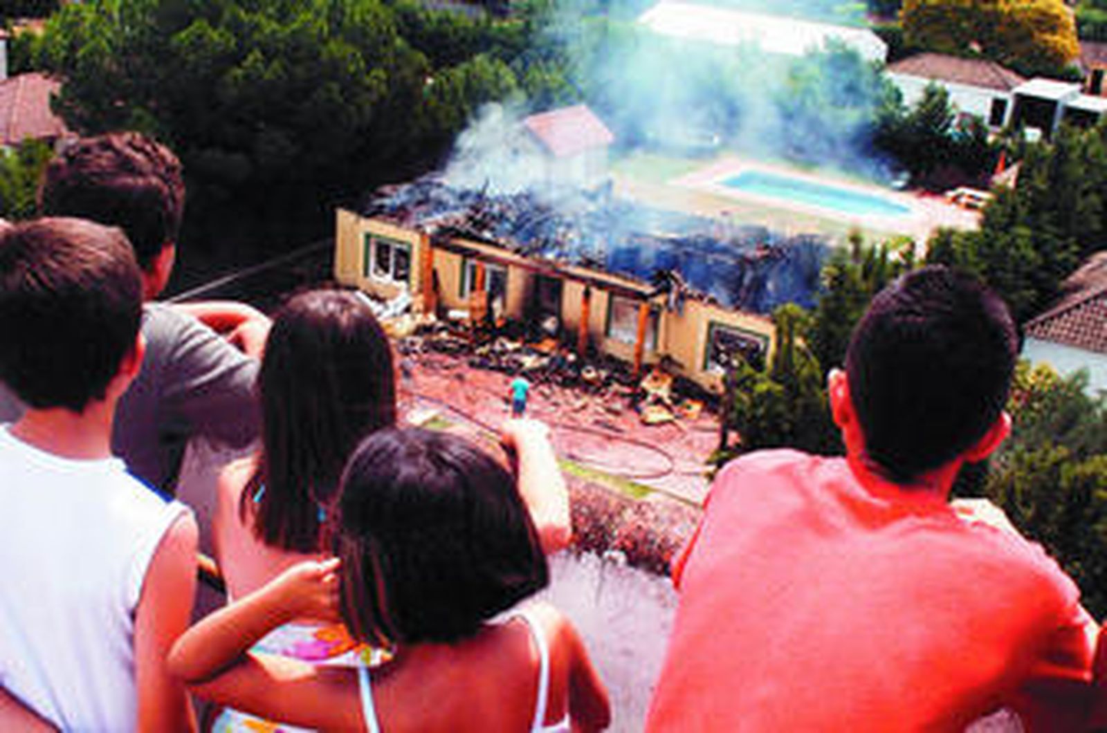 Un grupo de niños vecinos de la zona observan el enorme fuego.
