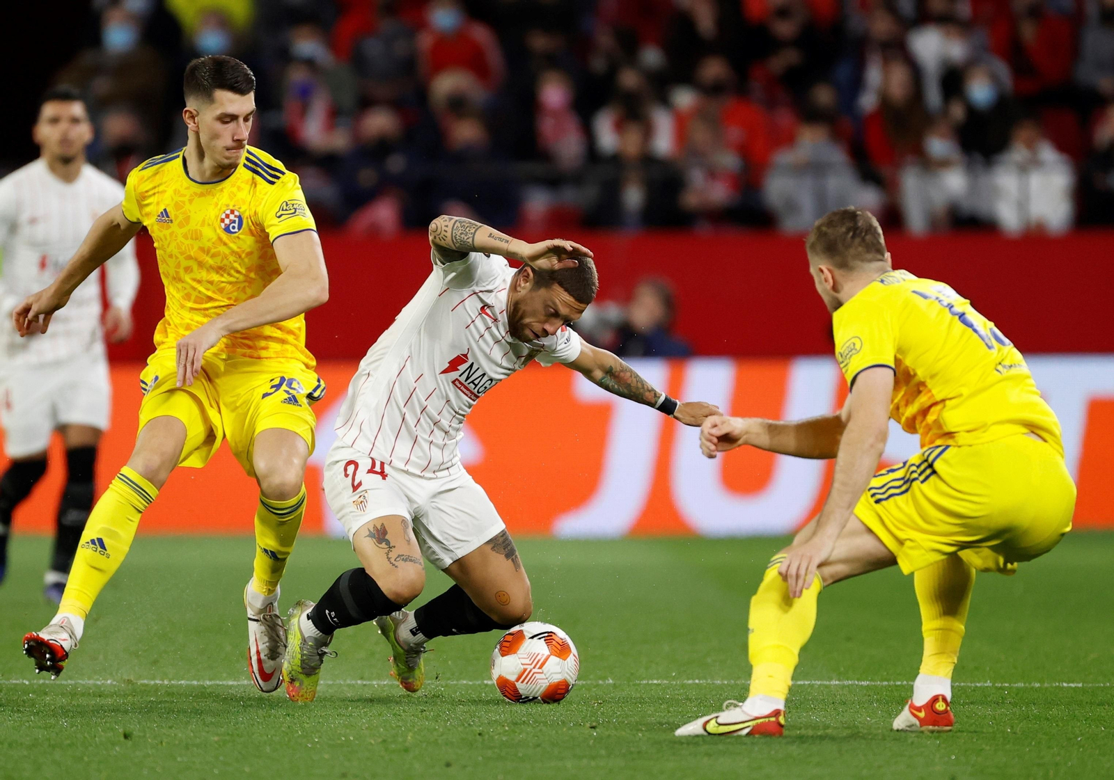 Papu Gómez, quien provocó el penalti, cae ante dos rivales.