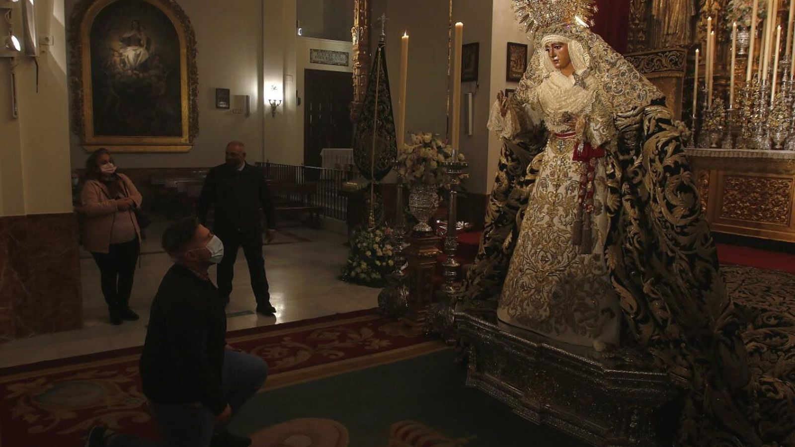 Un devoto se arrodilla ante la Esperanza de Triana.