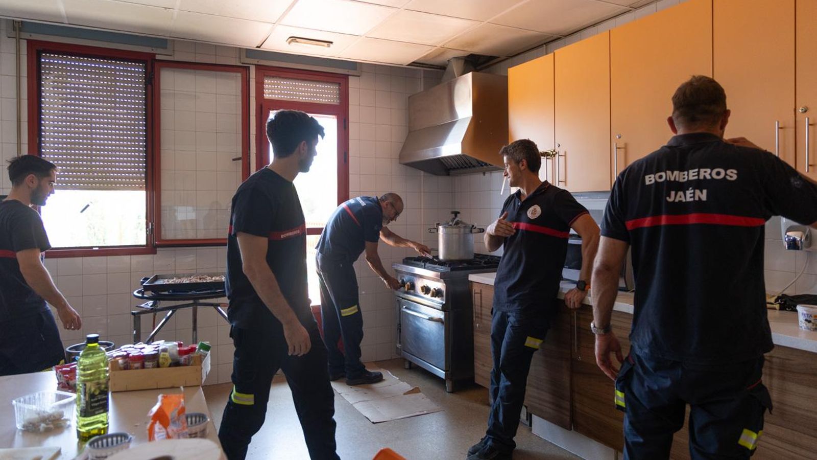Miembros del cuerpo de bomberos preparan el almuerzo.