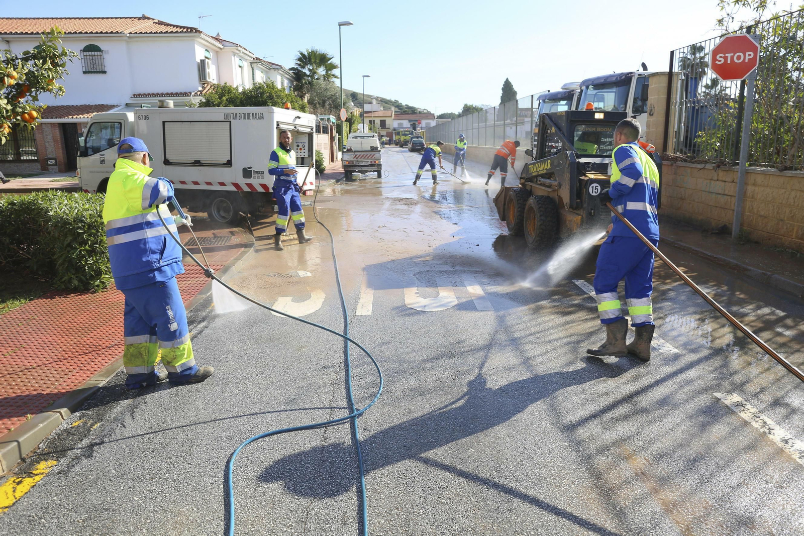 Operarios de Limasa baldean una de las calles del distrito.