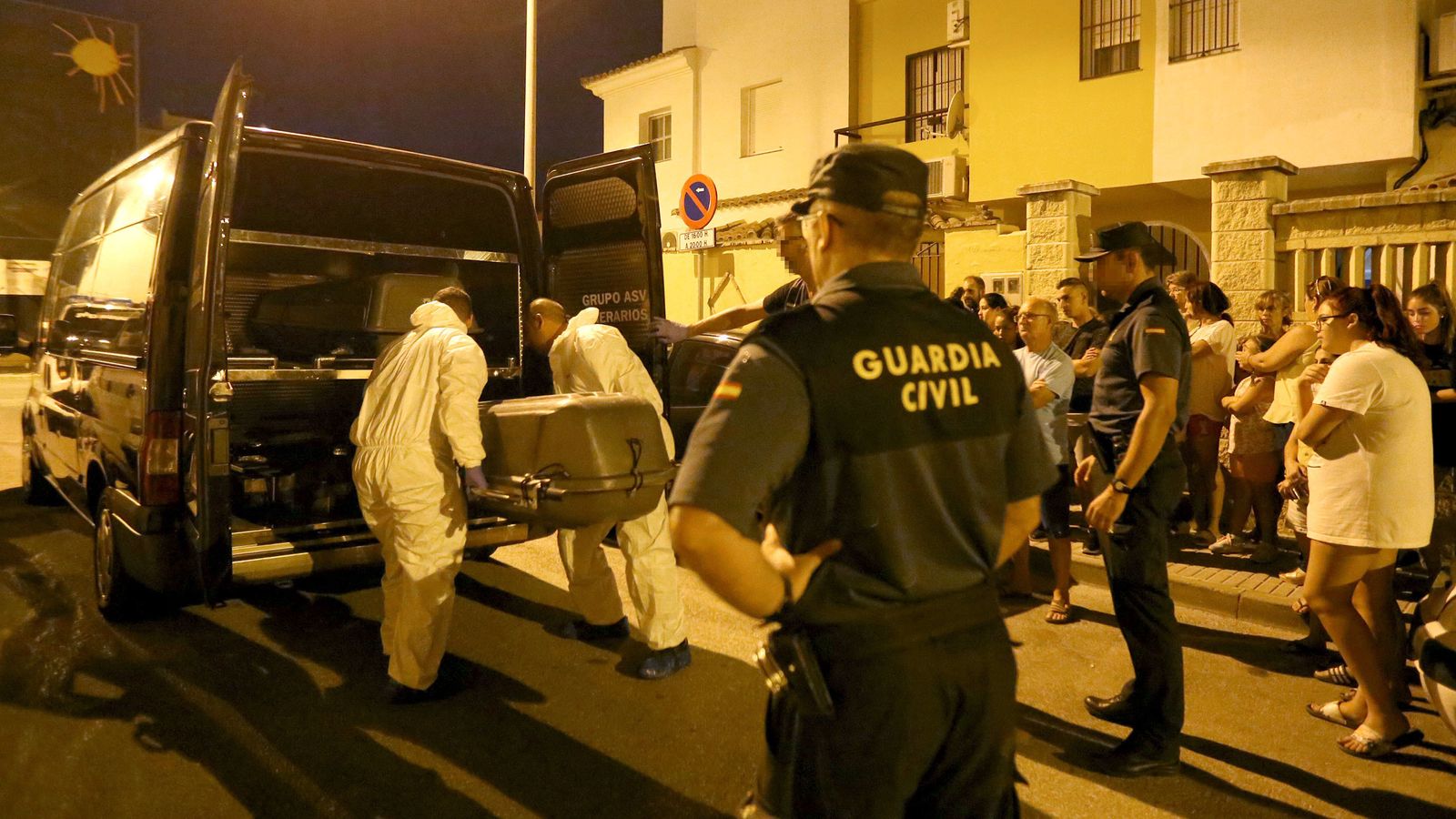 Personal funerario transporta el féretro con los restos mortales de la víctima.
