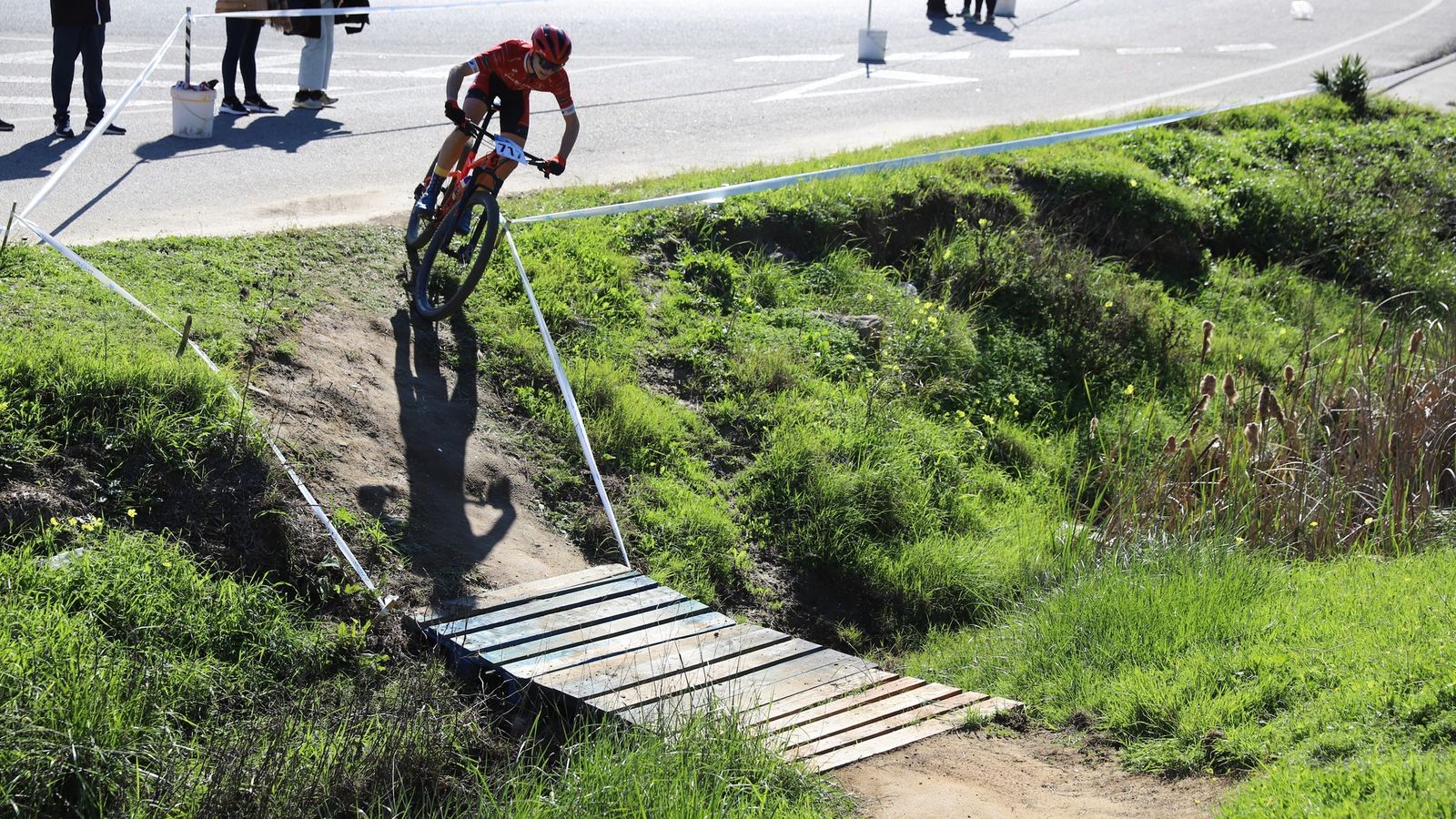 Maniobra del asfalto a la tierra a través de una pasarela de madera.