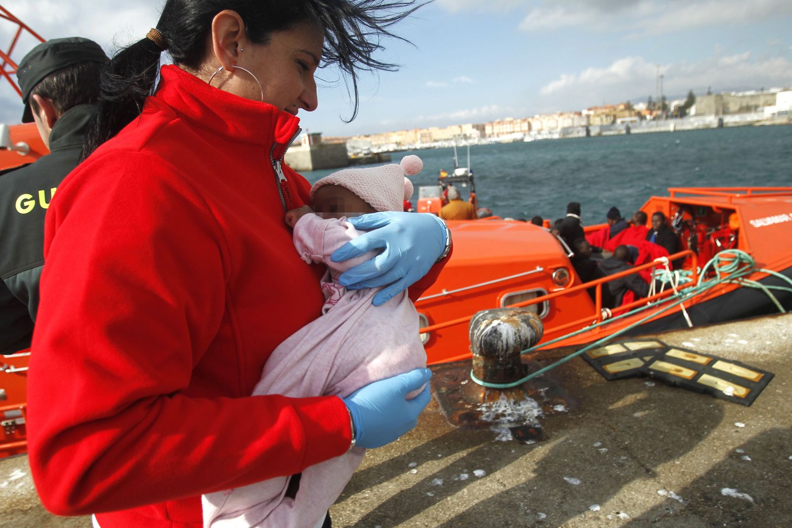Una voluntaria de Cruz Roja con uno de los bebés de la patera rescatada ayer frente a Tarifa.