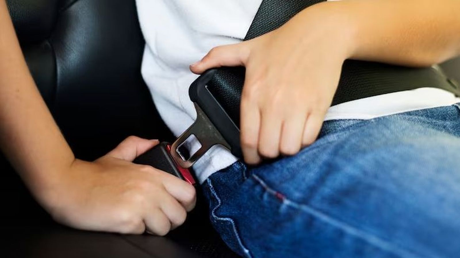 Niño abrochándose el ciunturón de seguridad