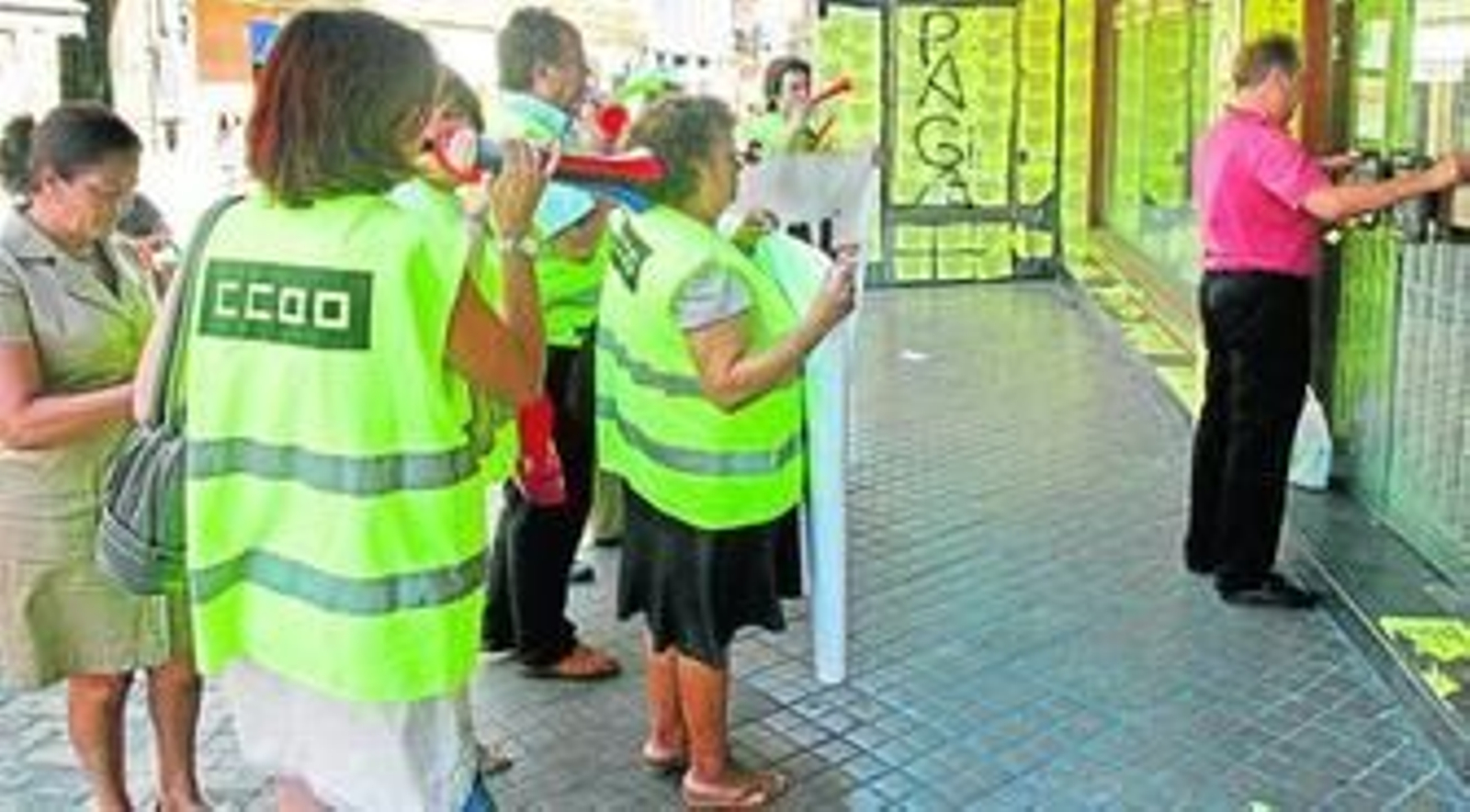 Los trabajadores de Rianal protestan al acabar la jornada laboral, frente a Ricardo Sáinz, mientras cierra la puerta del local.