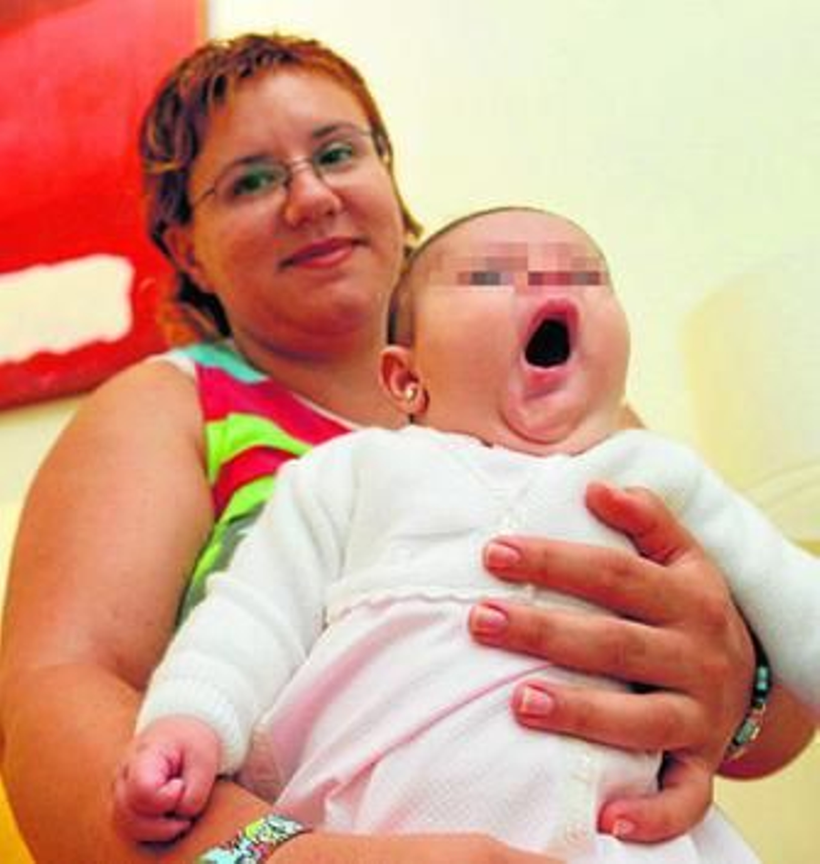 Una madre soltera sostiene a su hijo en brazos en una clínica de fecundación in vitro de Málaga.