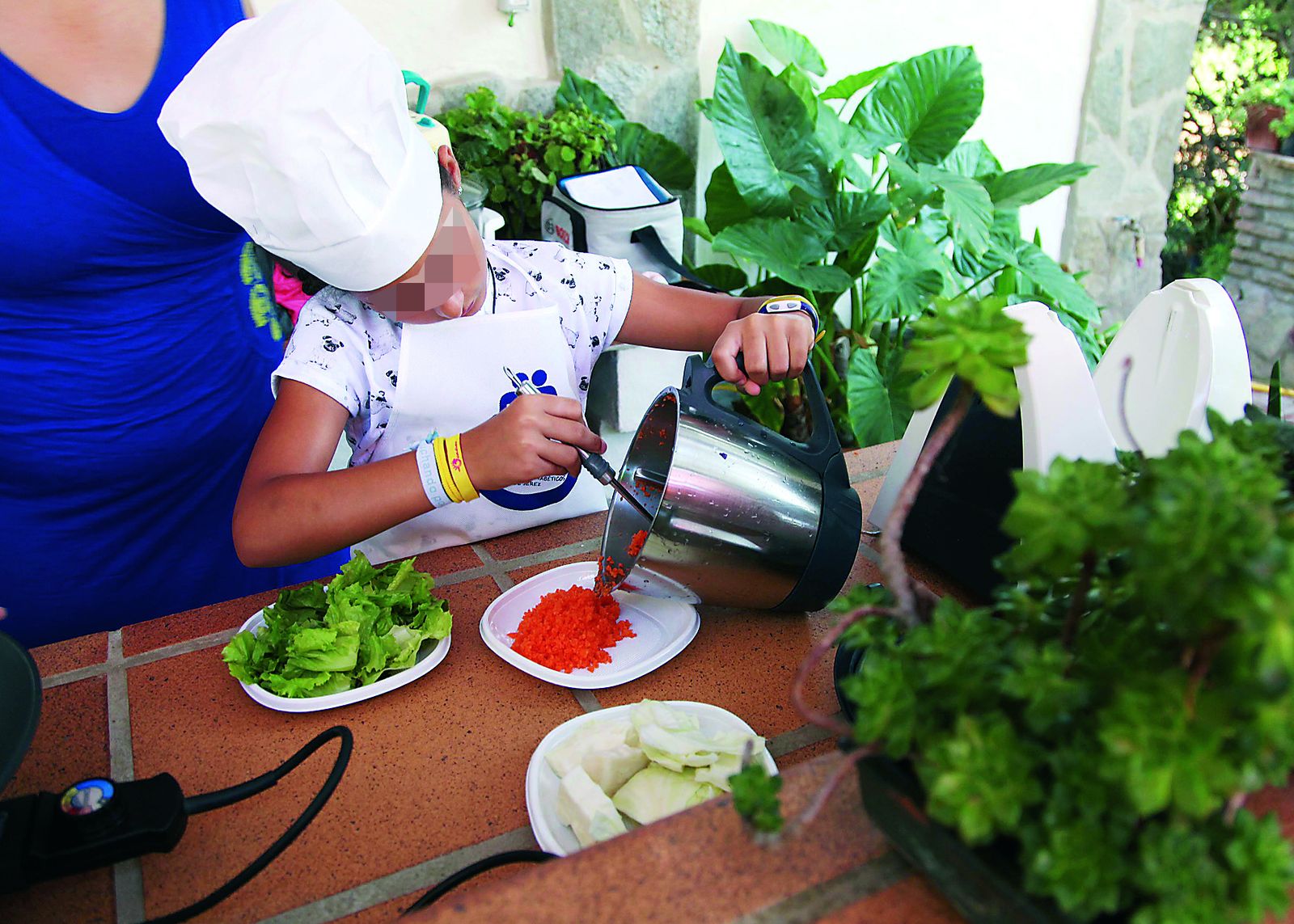 Una niña elaborando un menú en uno de los talleres de alimentación que organiza la asociación.