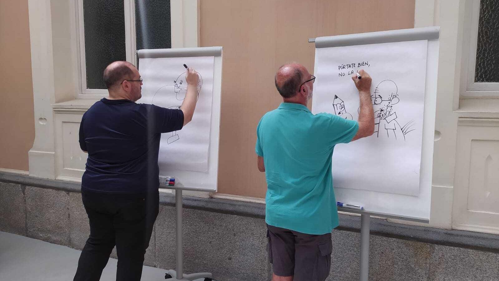 Dos de los artistas gráficos de "En el AVE con humor" pintando durante el encuentro celebrado en Madrid Dos de los artistas gráficos de "En el AVE con humor" pintando durante el encuentro celebrado en Madrid