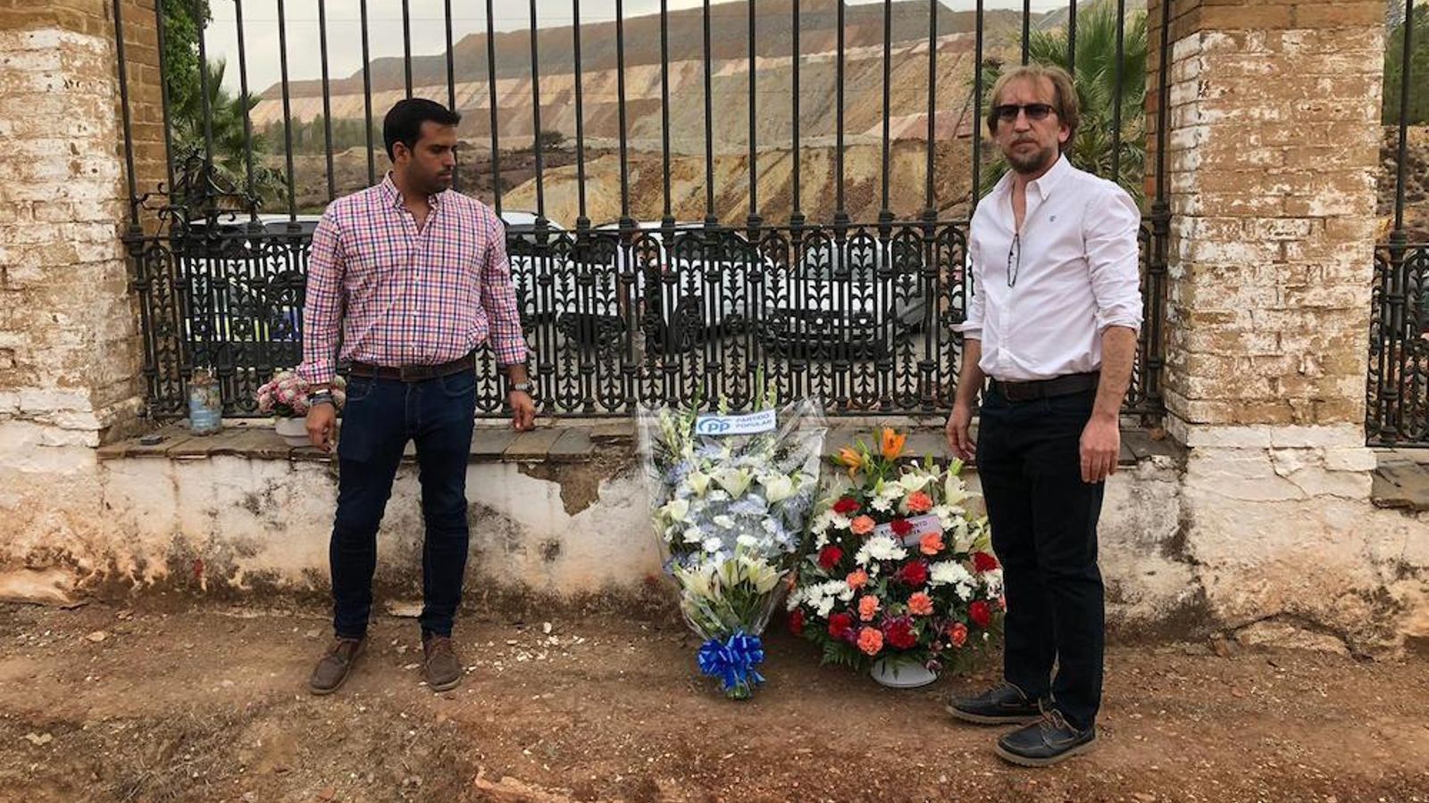 Al alcalde junto a uno de sus concejales en la ofrenda floral ante las fosas comunes.