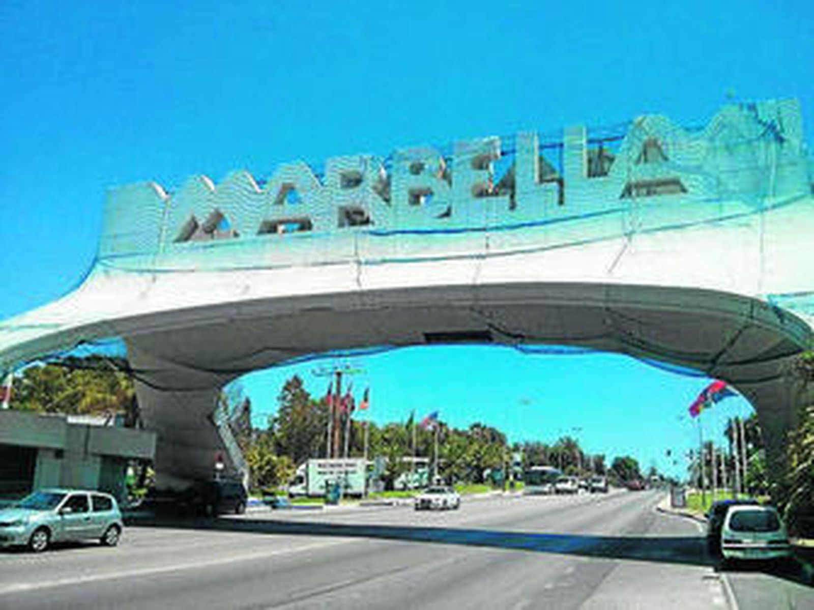 Coches cruzan el arco que da la bienvenida a Marbella.