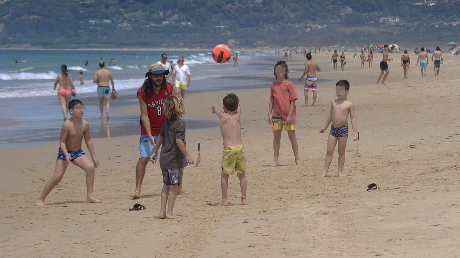 Varios niños y un adulto juegan en la orilla en Tarifa, este sábado.