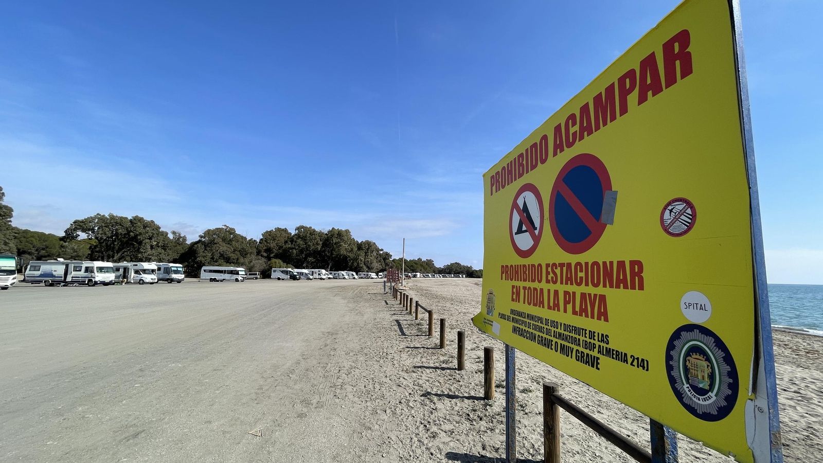 Decenas de caravanas frente al cartel de prohibición en la playa de Quitapellejos (Palomares).