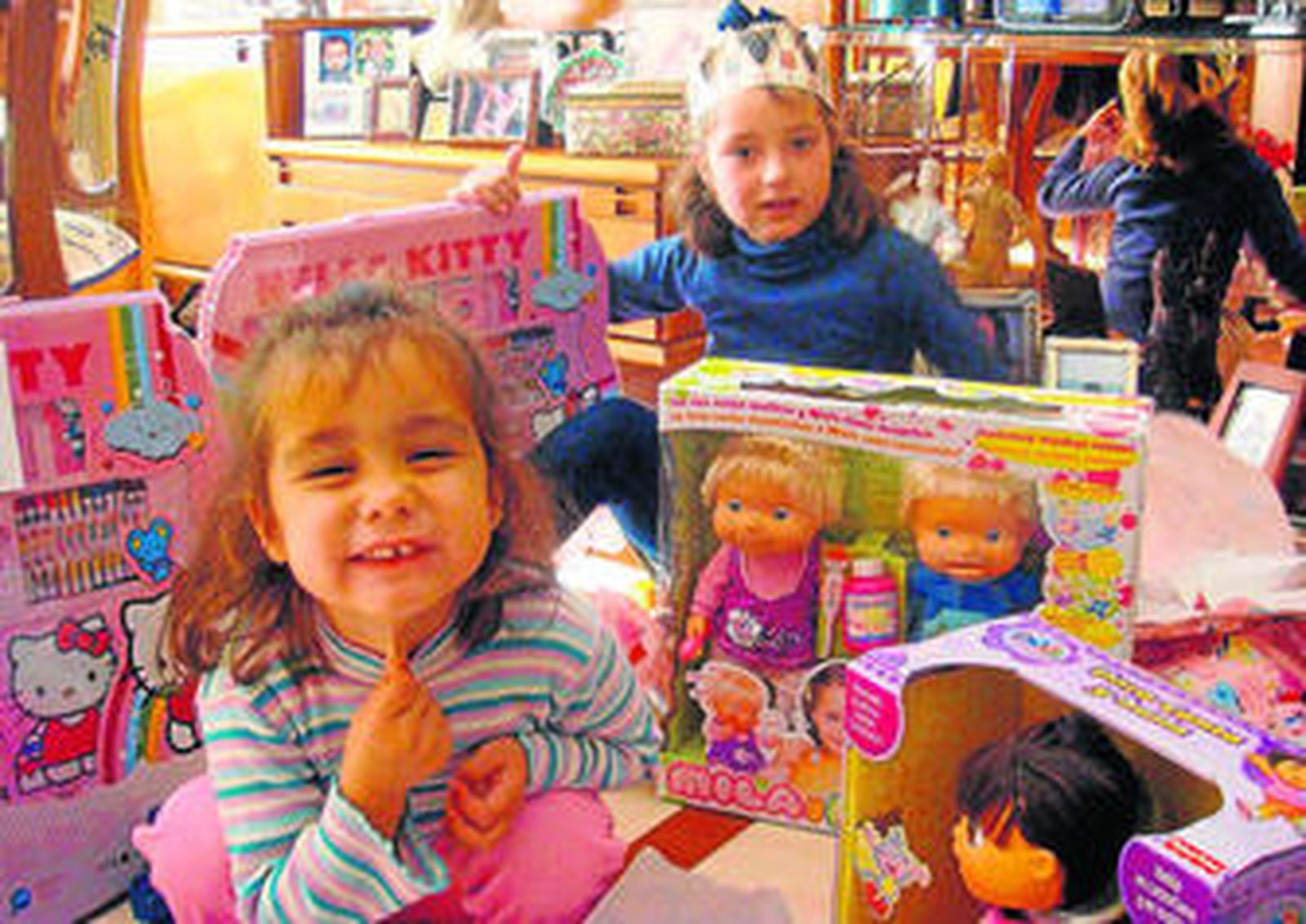 1. Dos niñas abren los regalos, a primera hora, que les han dejado  los Reyes Magos y los muestran ilusionadas. 2. Este pequeño ciclista aprende a montar en su nueva bici. 3. Un padre y su hijo pasean en un tándem. 4. Varias niñas se divierten con uno de los juguetes recibidos.