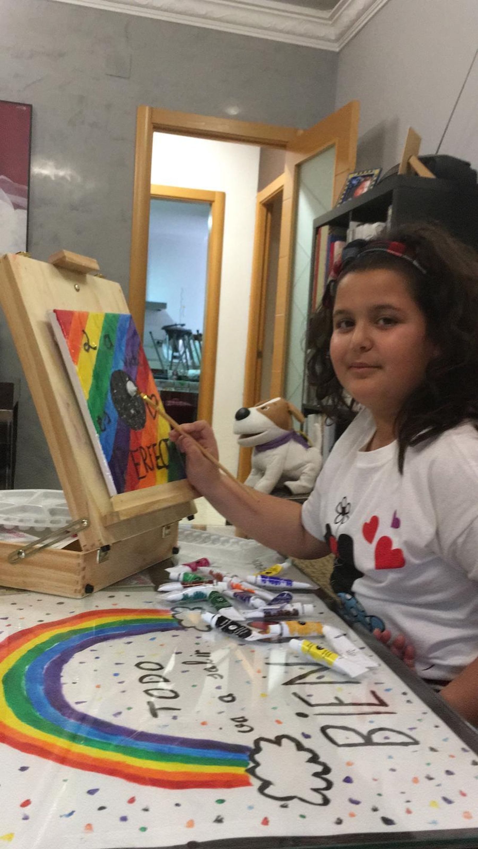 Una niña pinta un cuadro con mensajes de positividad