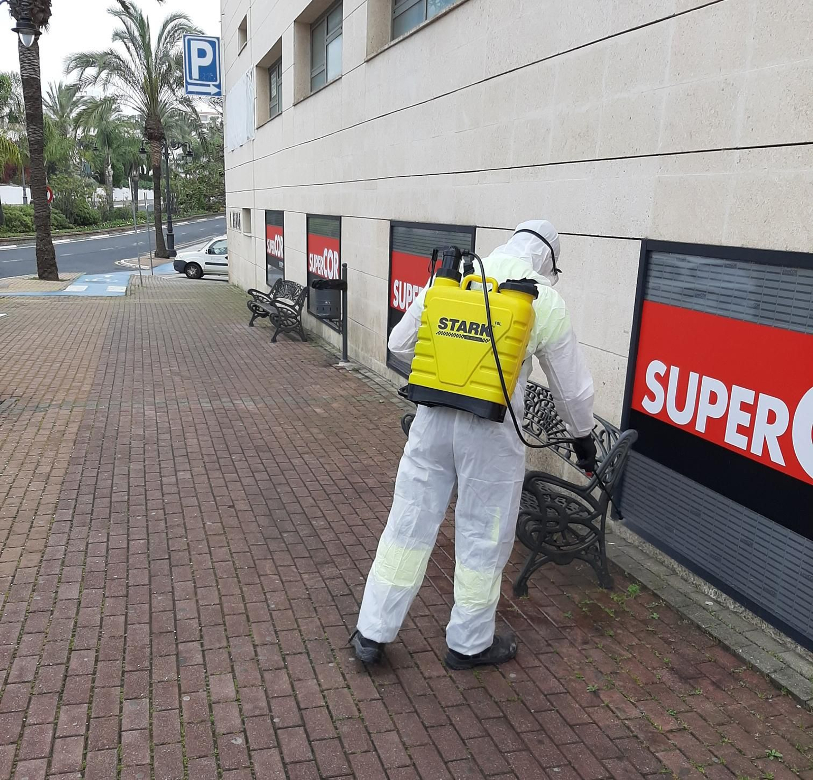 Un operario del Ayuntamiento de Estepona desinfecta las inmediaciones de un supermercado.