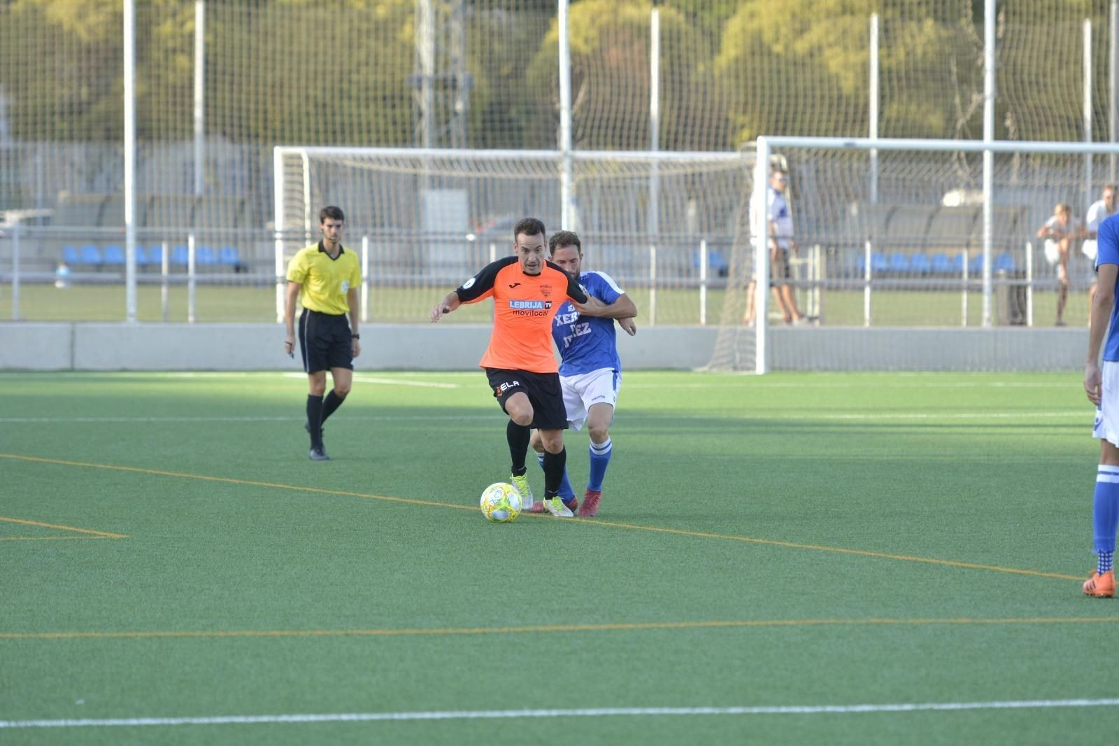 Juanca se lleva el balón mientras Yeray le agarra del brazo.