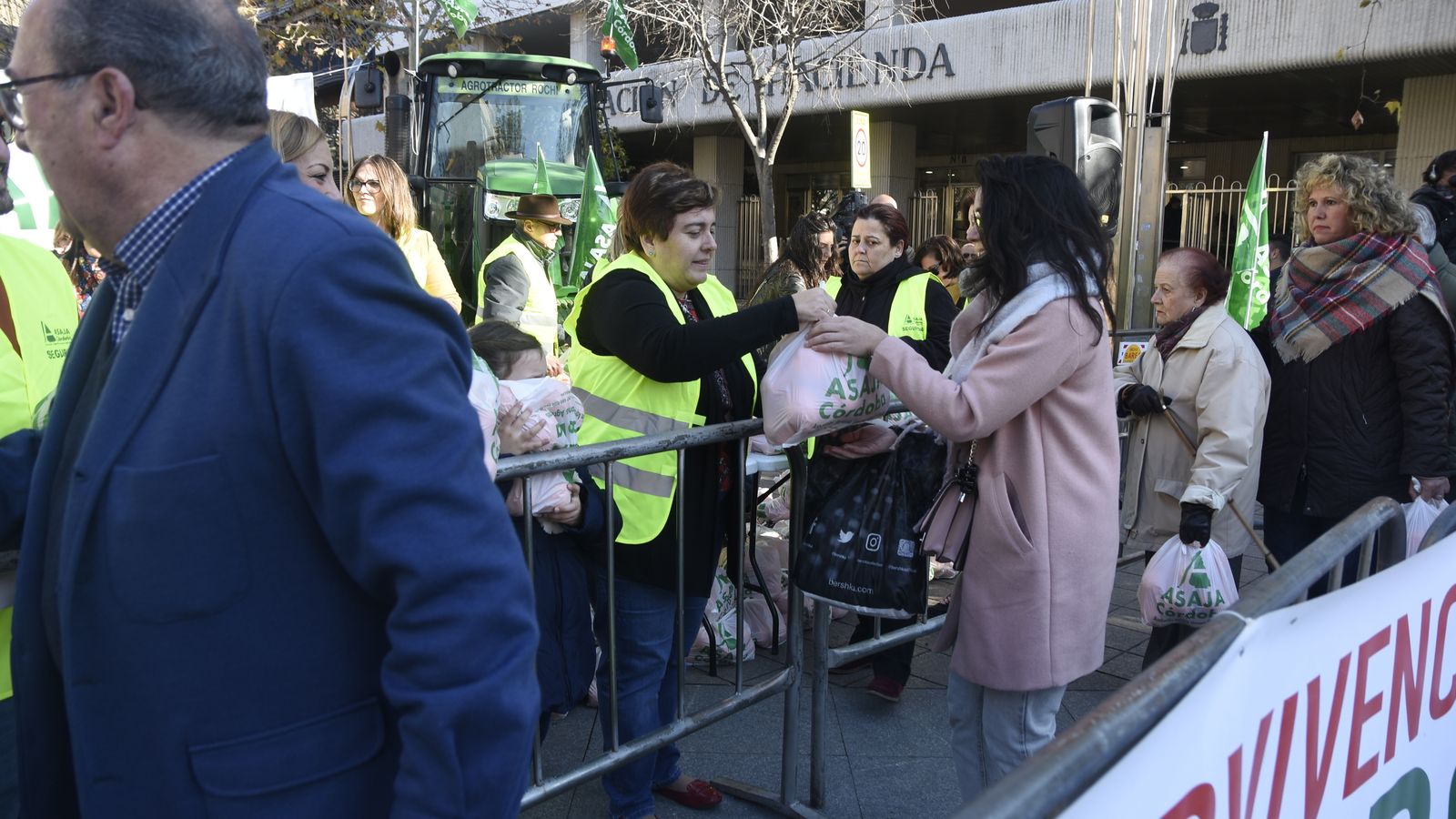 Una agricultora entrega una bolsa de naranja a una mujer
