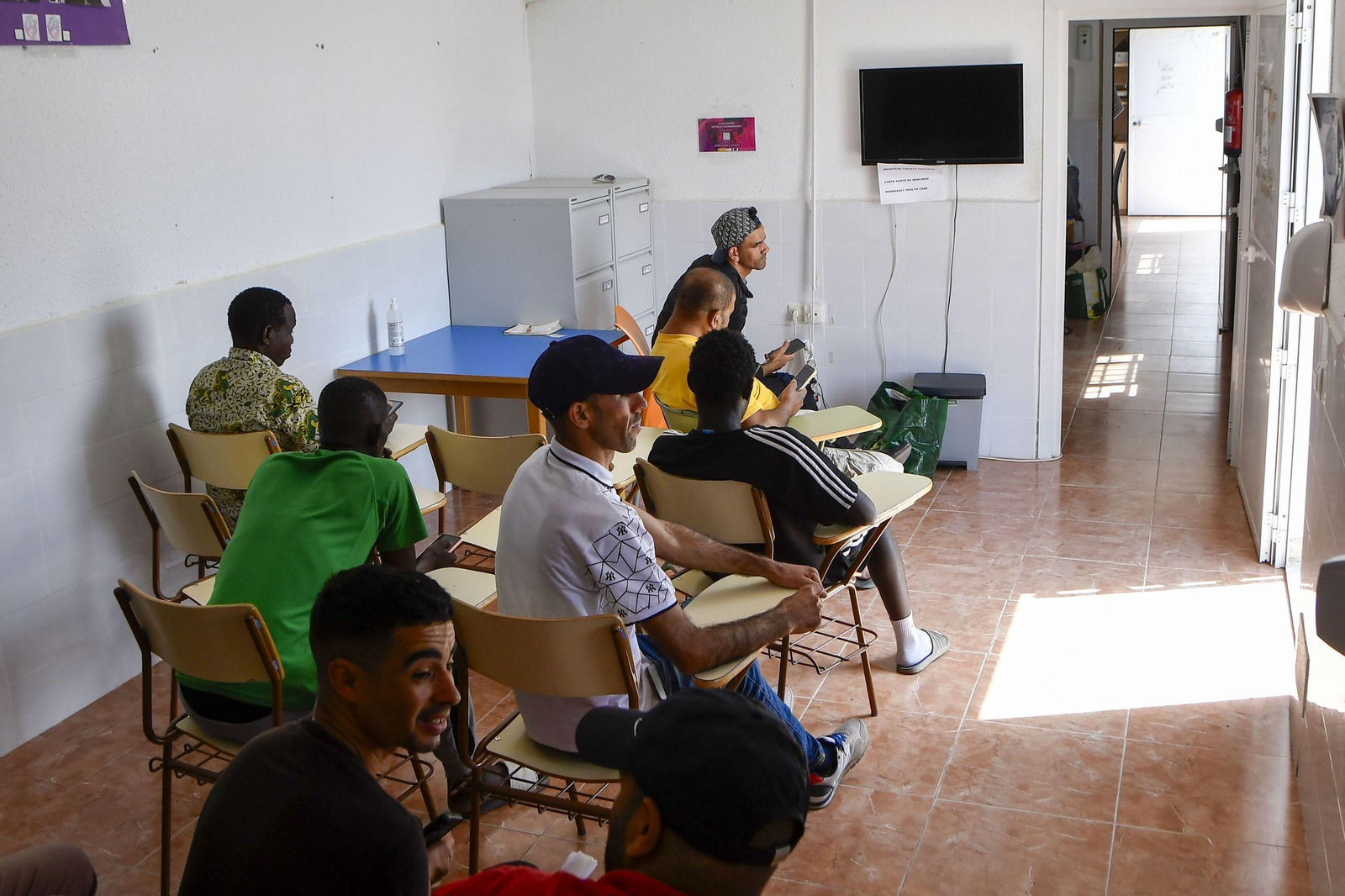Inmigrantes aguardan en la sala de espera del centro de día que gestiona Almería Acoge en San Isidro.