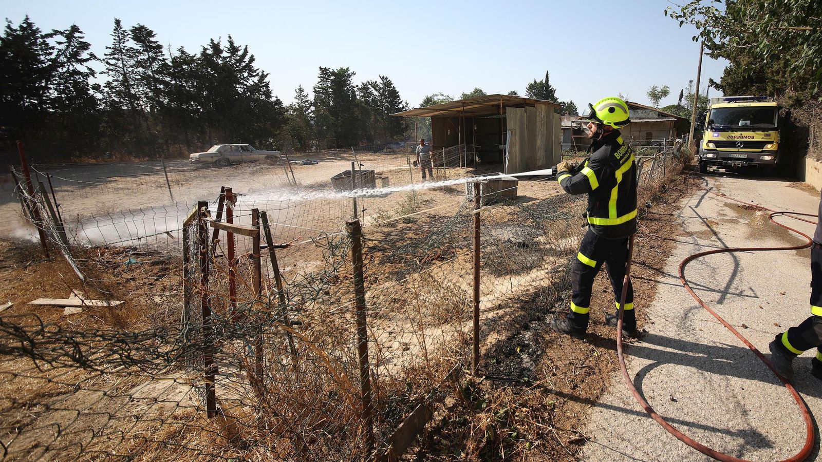 Un bombero refrescando la tierra de una finca en la Hijuela del Serrallo.