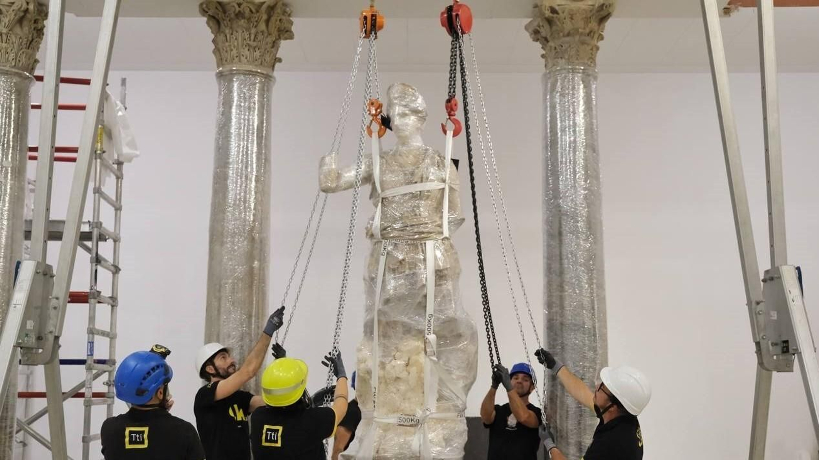 Los operarios mueven las poleas para el traslado de la escultura de Diana.
