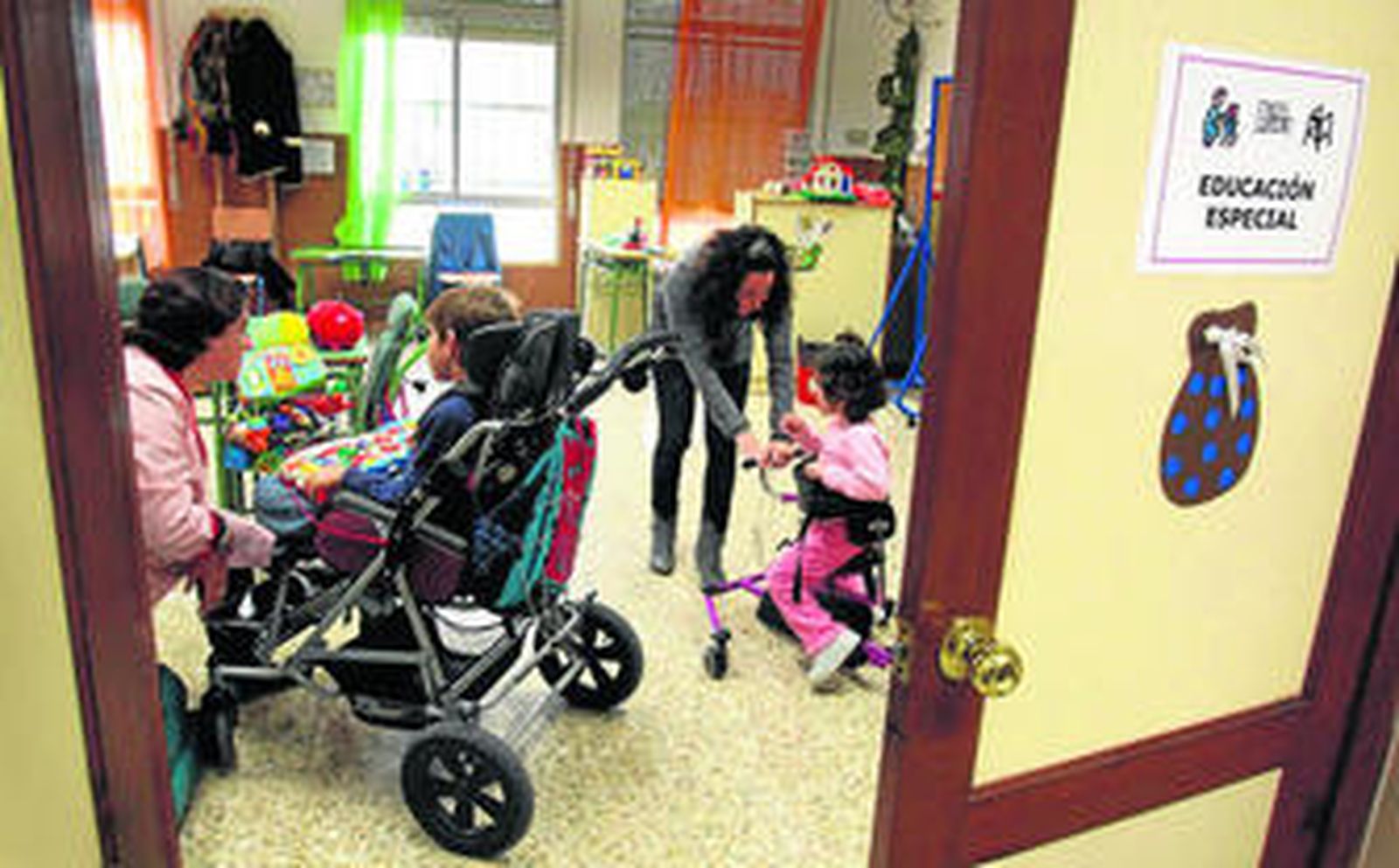 Loli Carmen Giner y Charo Reina atienden a dos de los alumnos del aula específica en el colegio Luis Buñuel.
