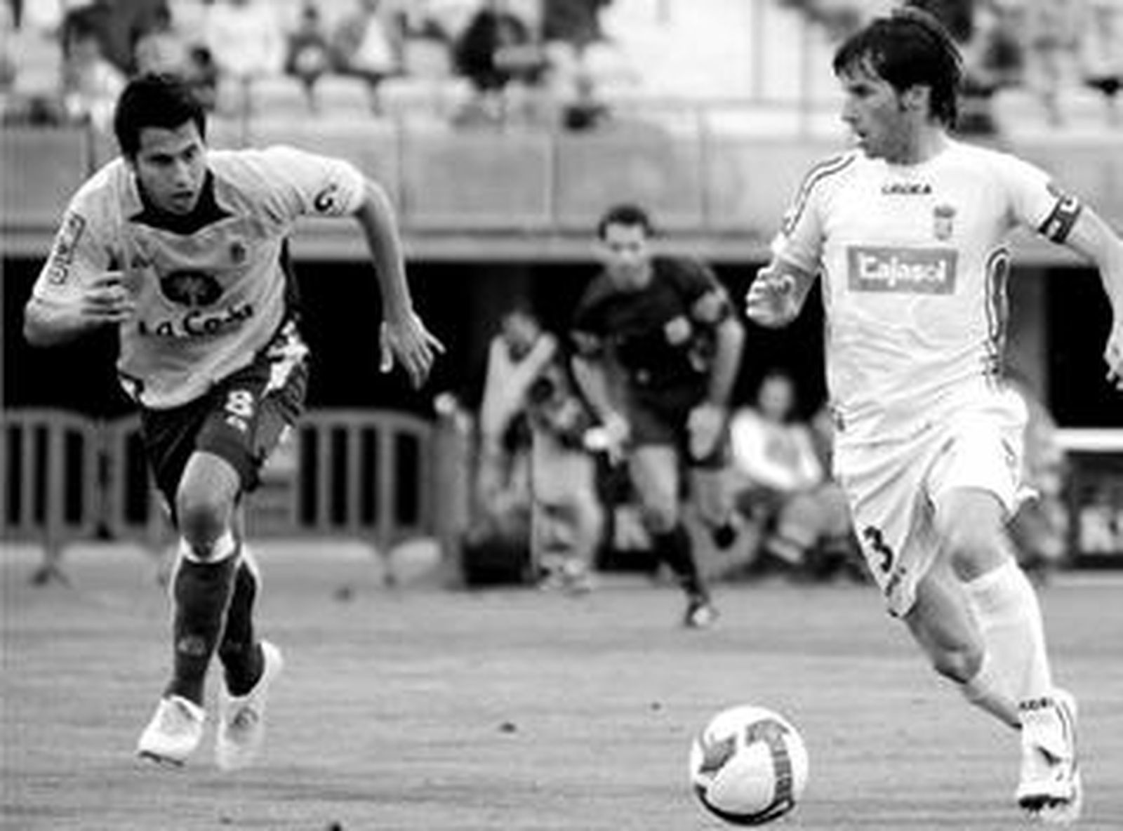 El lateral azulino Mendoza conduce el balón ante un jugador amarillo.