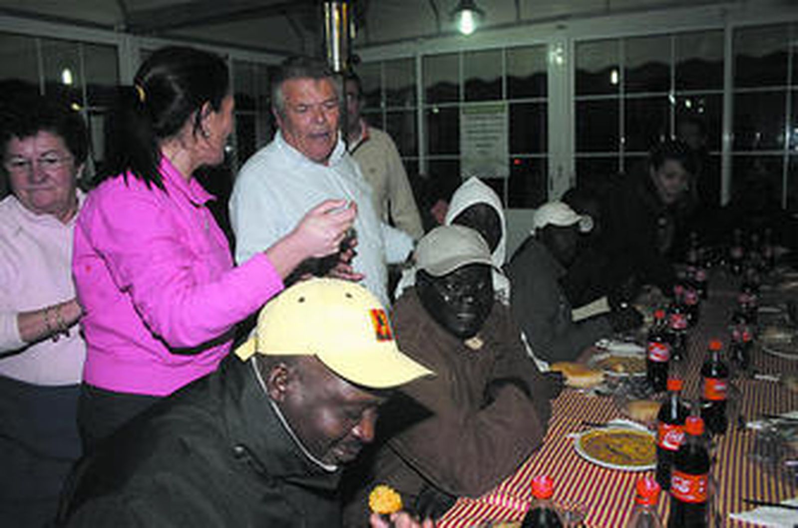 De pie Patrocinio Mora atendiendo a los inmigrantes africanos.