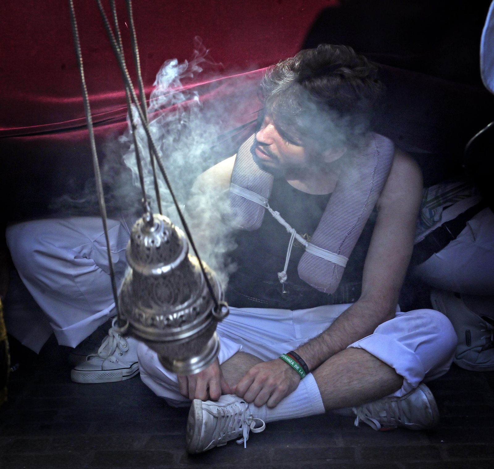 Un costalero descansando con el paso arriado.