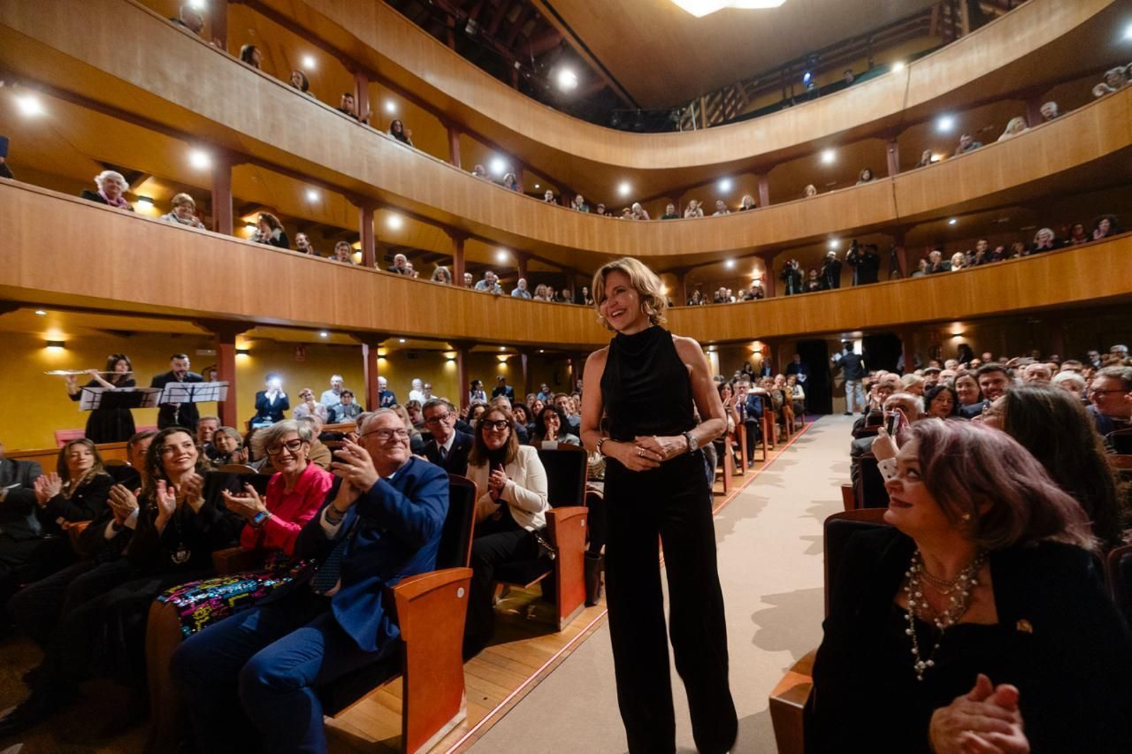 La periodista, recibiendo el aplauso del público a su entrada al teatro.