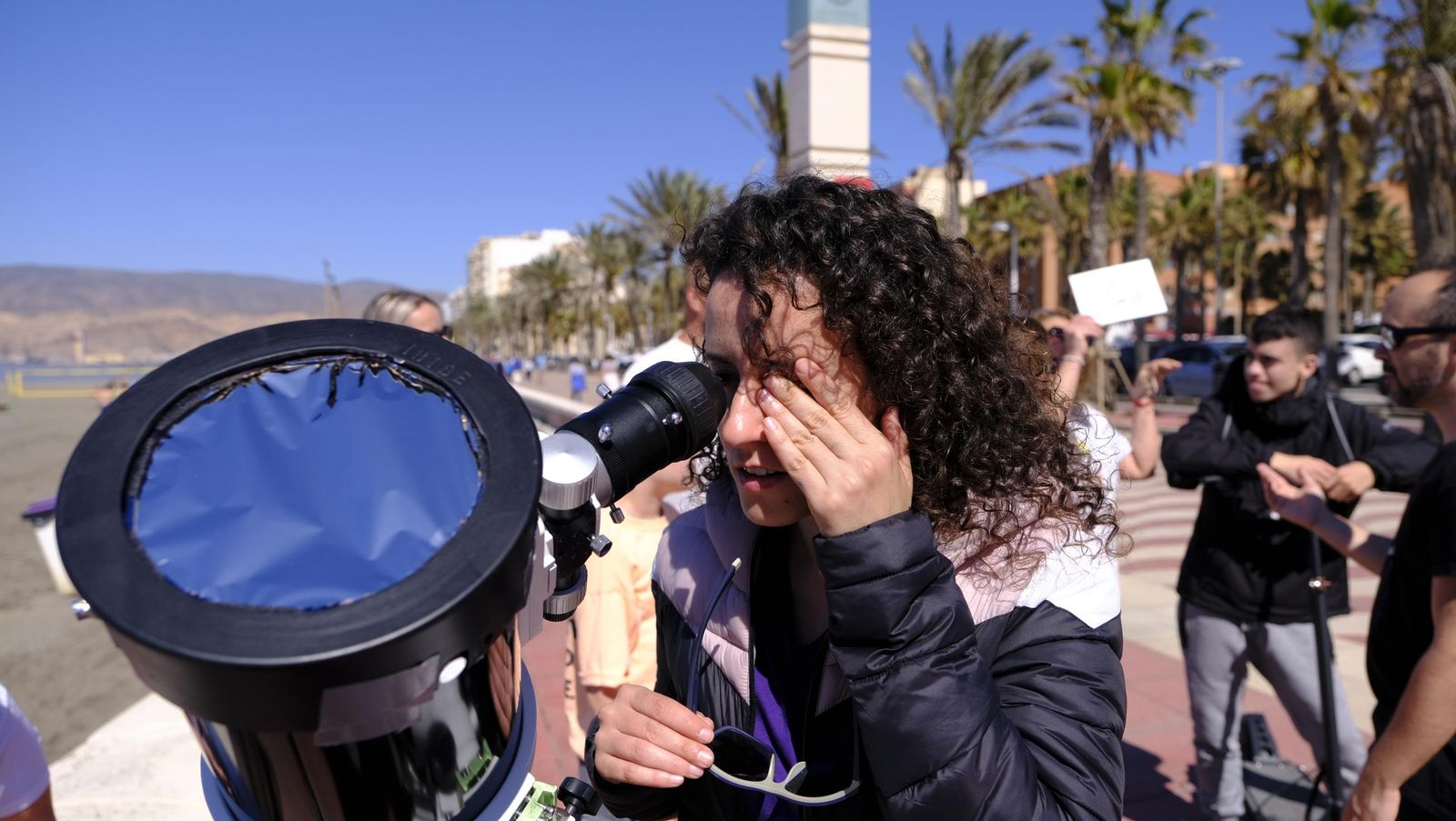 Almería observa el eclipse solar desde el Paseo Marítimo, en imágenes