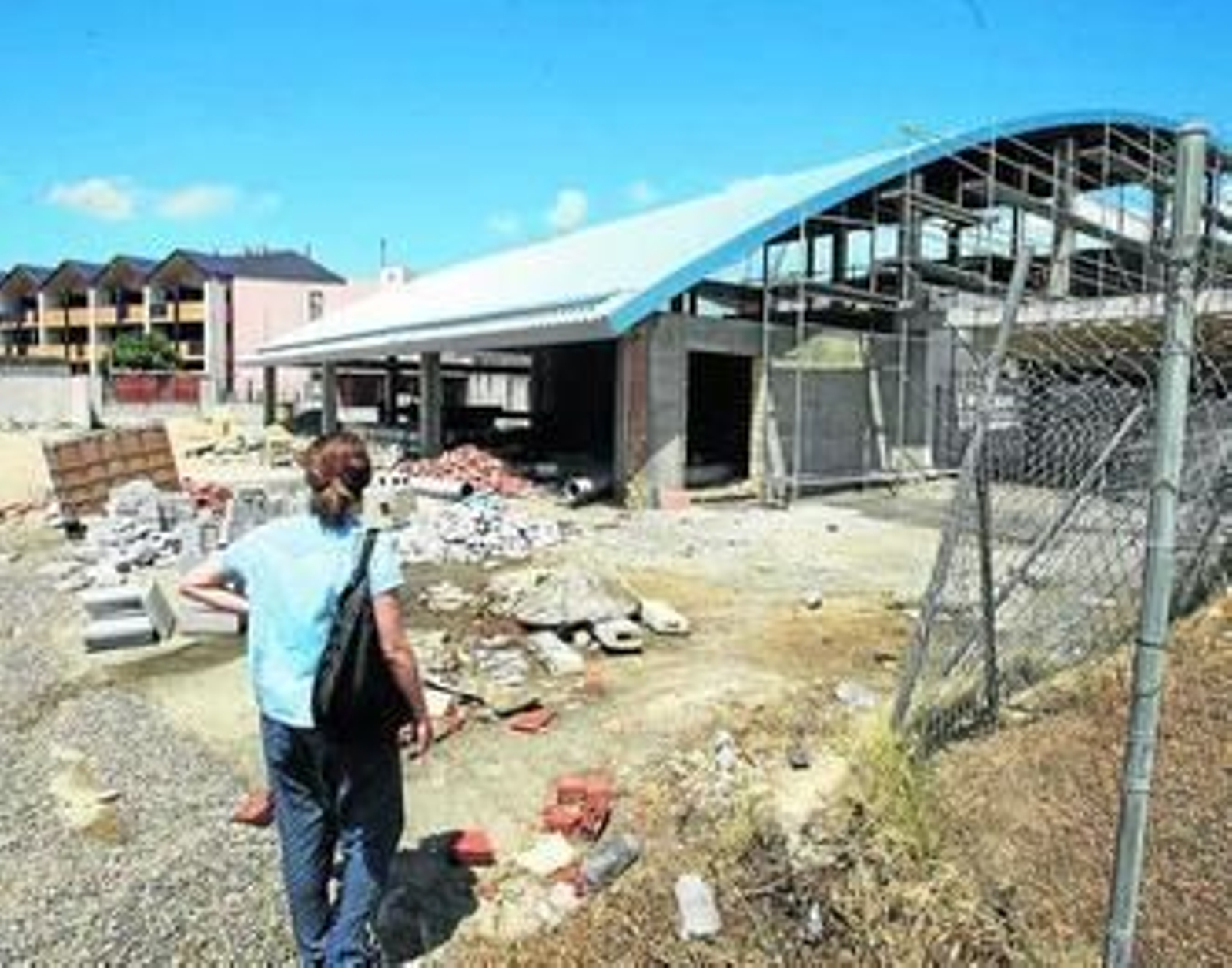 La trasera de la piscina a medio hacer y los balcones, llenos de palomas, del hotel La Alquería.