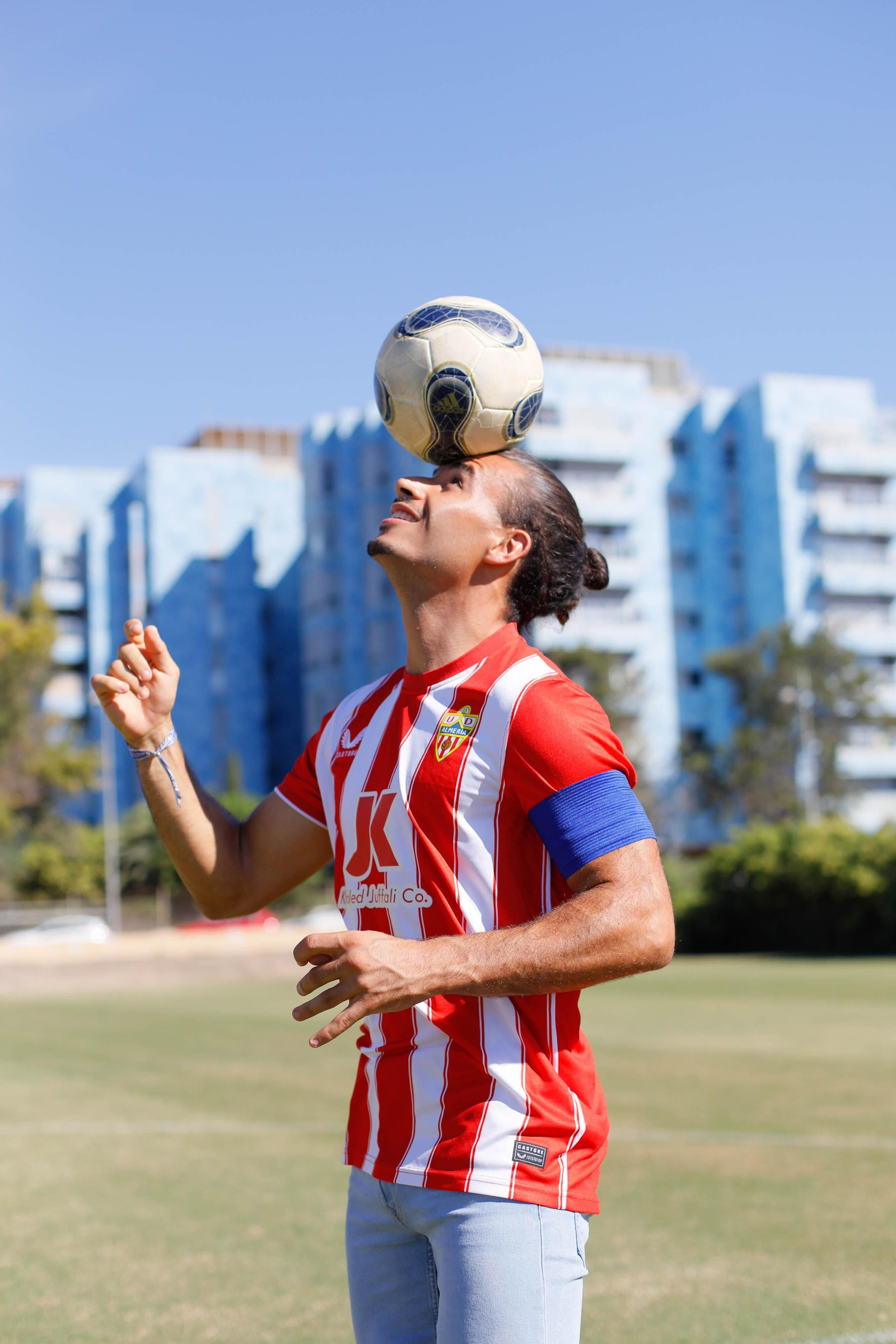 Aarón Romero da toques a un balón portando la camiseta rojiblanca y el brazalete de capitán en su brazo.