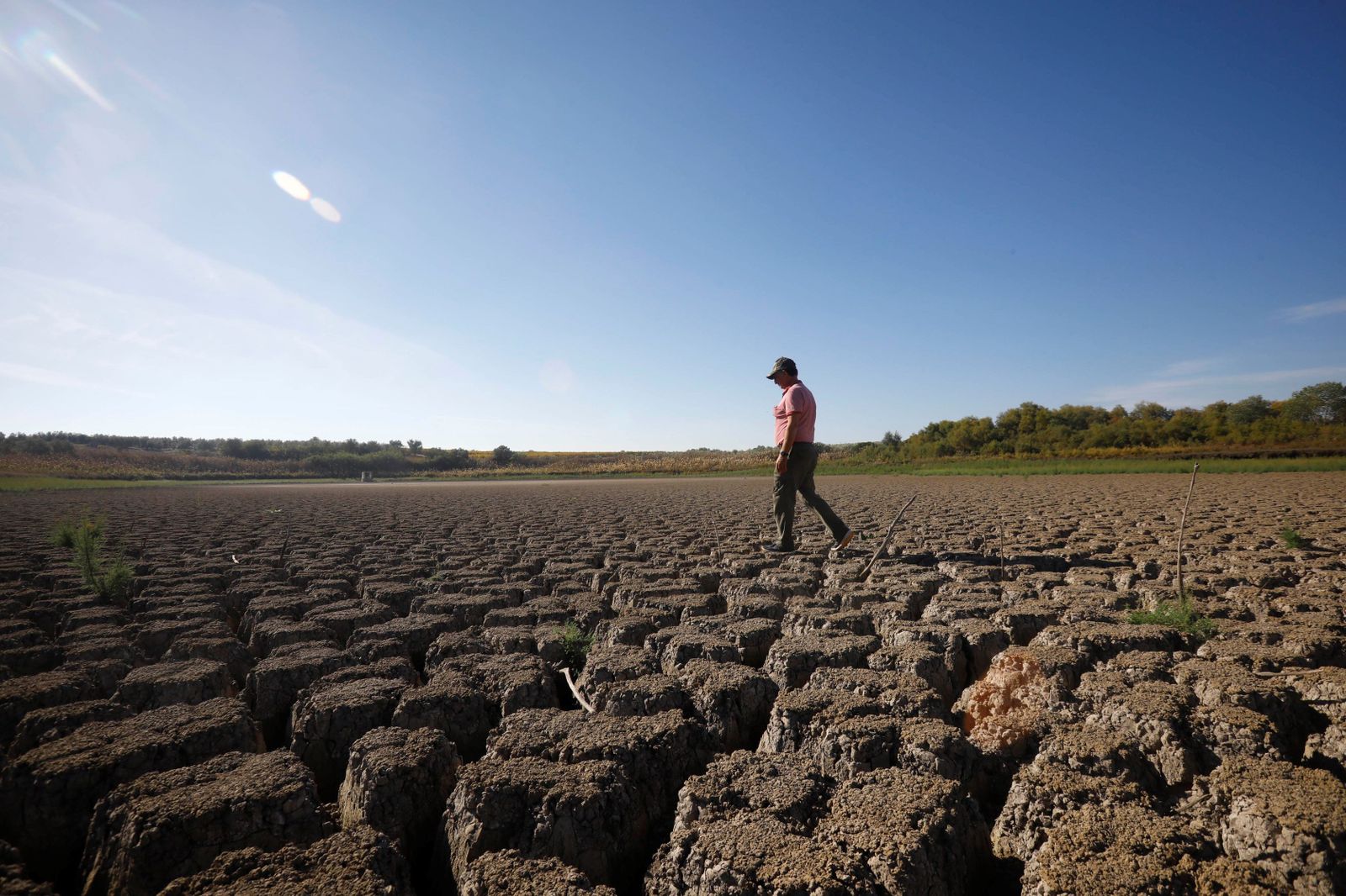 Un hombre camina por el lecho seco de la laguna del Rincón.